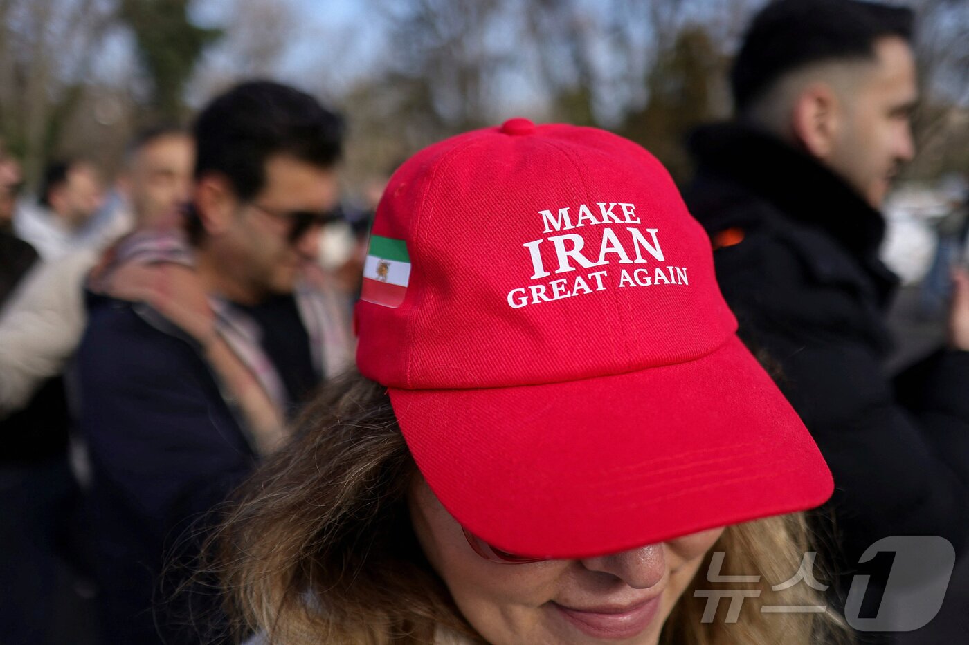본문 이미지 - 루마니아의 이란 반정부 시위에서 한 참가자가 트럼프 미국 대통령의 '미국을 다시 위대하게' 구호를 본떠 '이란을 다시 위대하게' 라고 적힌 모자를 쓰고 있다.2026.03.01 ⓒ 로이터=뉴스1