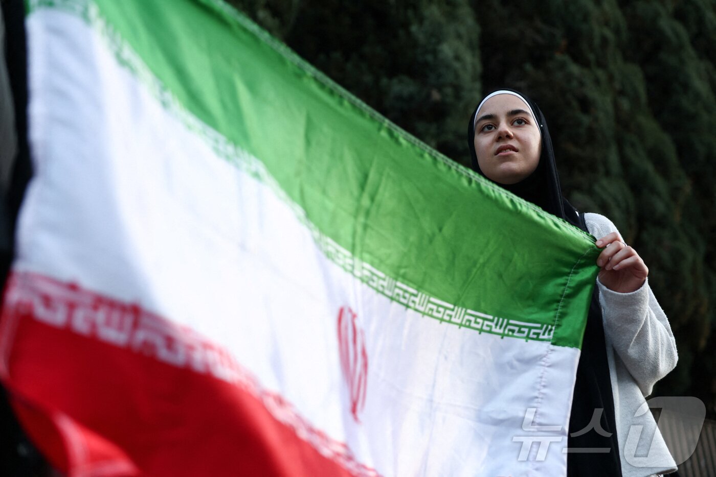 본문 이미지 - 이란 국기를 든 여성. ⓒ 로이터=뉴스1