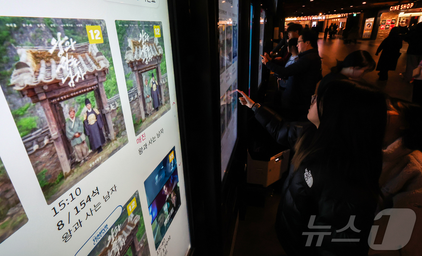 (서울=뉴스1) 김진환 기자 = 2일 오후 서울의 한 영화관을 찾은 시민들이 영화 '왕과 사는 남자' 티켓을 구매하고 있다.배급사 쇼박스에 따르면 이날 오후 1시 20분께 누적관객 …