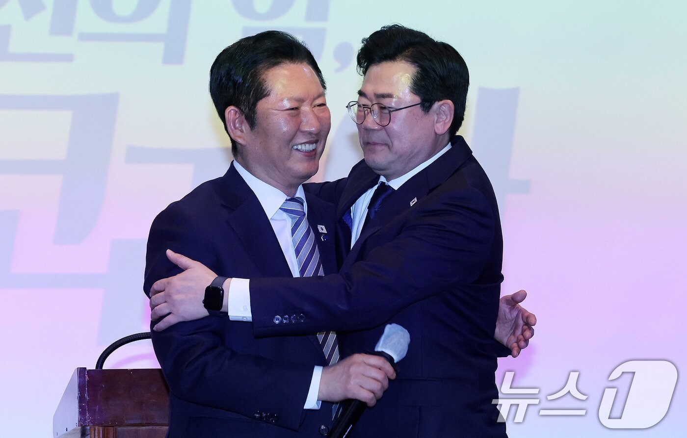 본문 이미지 - 박찬대 더불어민주당 의원이 2일 오후 인천 미추홀구 인하대학교 본관 대강당에서 열린 ‘인천의 힘, G3 코리아’ 출판기념회에 참석한 정청래 대표를 포옹하고 있다. 2026.3.2 ⓒ 뉴스1 박지혜 기자