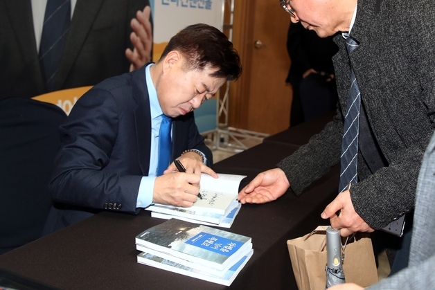 저서에 사인해 주는 오영훈 제주지사