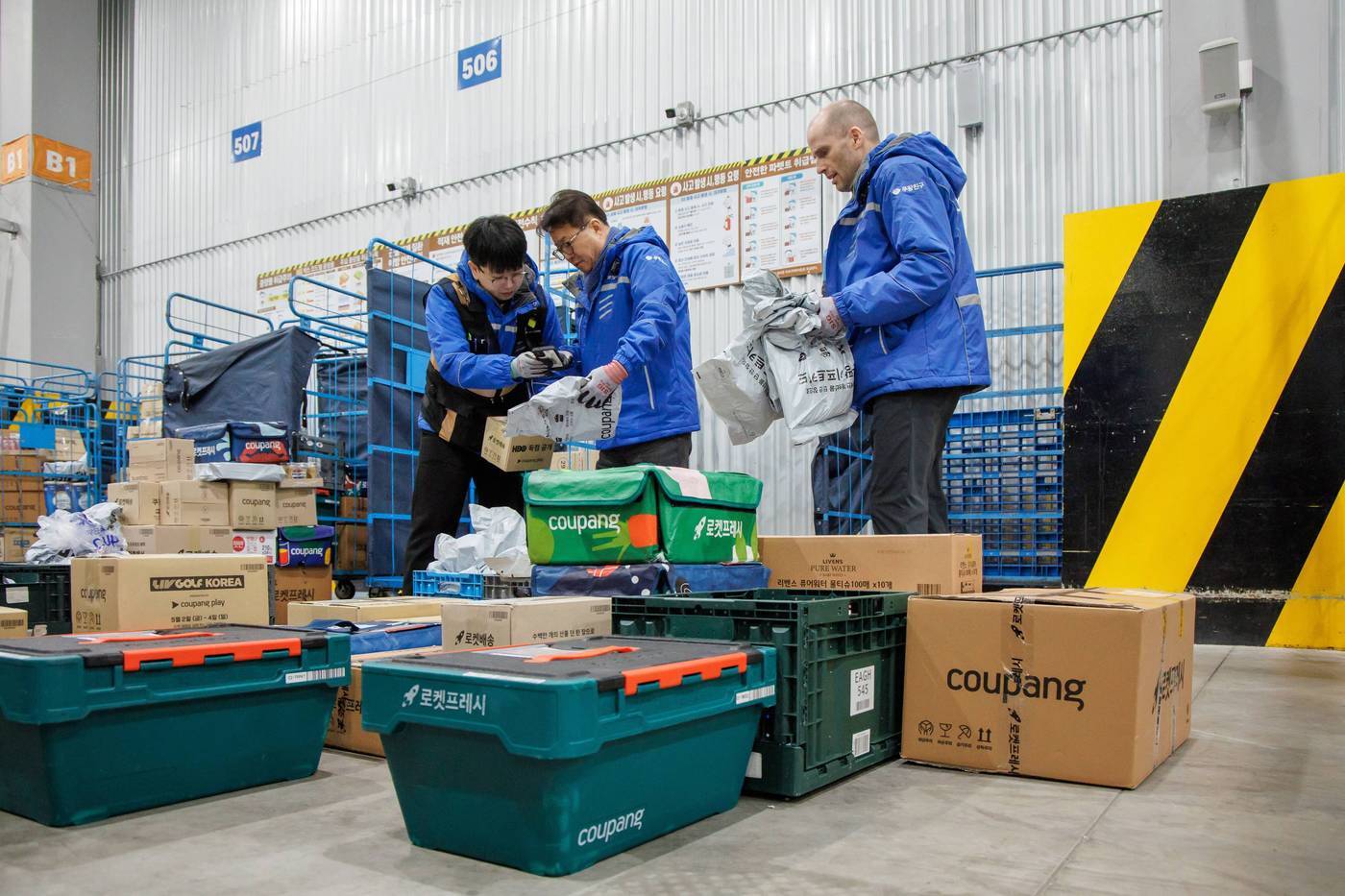 본문 이미지 -  로저스 대표와 염태영 더불어민주당 의원이 배송체험에 앞서 택배물품 상차 등 준비 작업을 하고 있는 모습