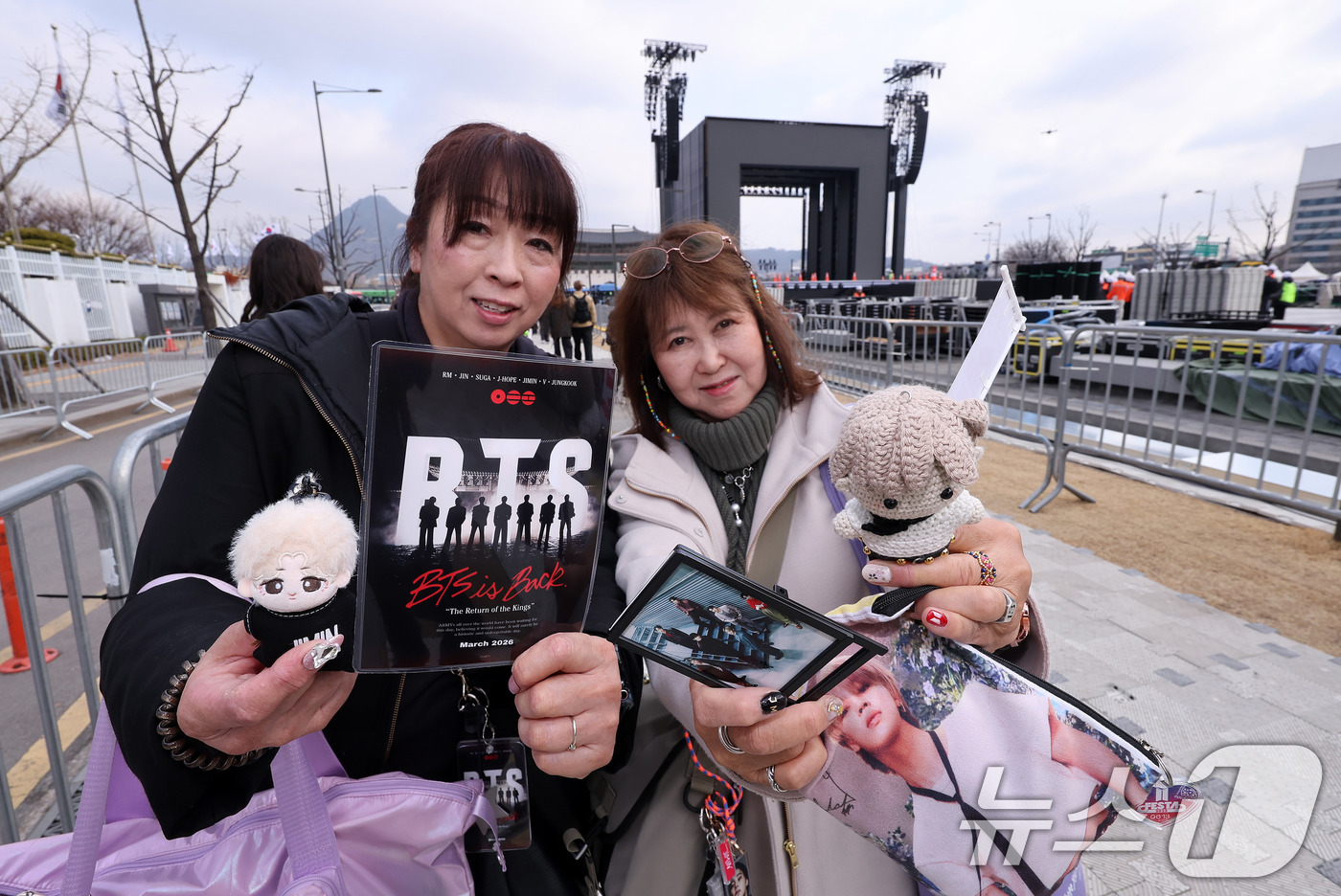 (서울=뉴스1) 박지혜 기자 = 방탄소년단(BTS) 완전체 컴백 공연을 하루 앞둔 20일 서울 광화문광장 공연장 앞에 일본에서 온 아미(ARMY·팬덤명)들이 굿즈를 들어보이고 있다 …