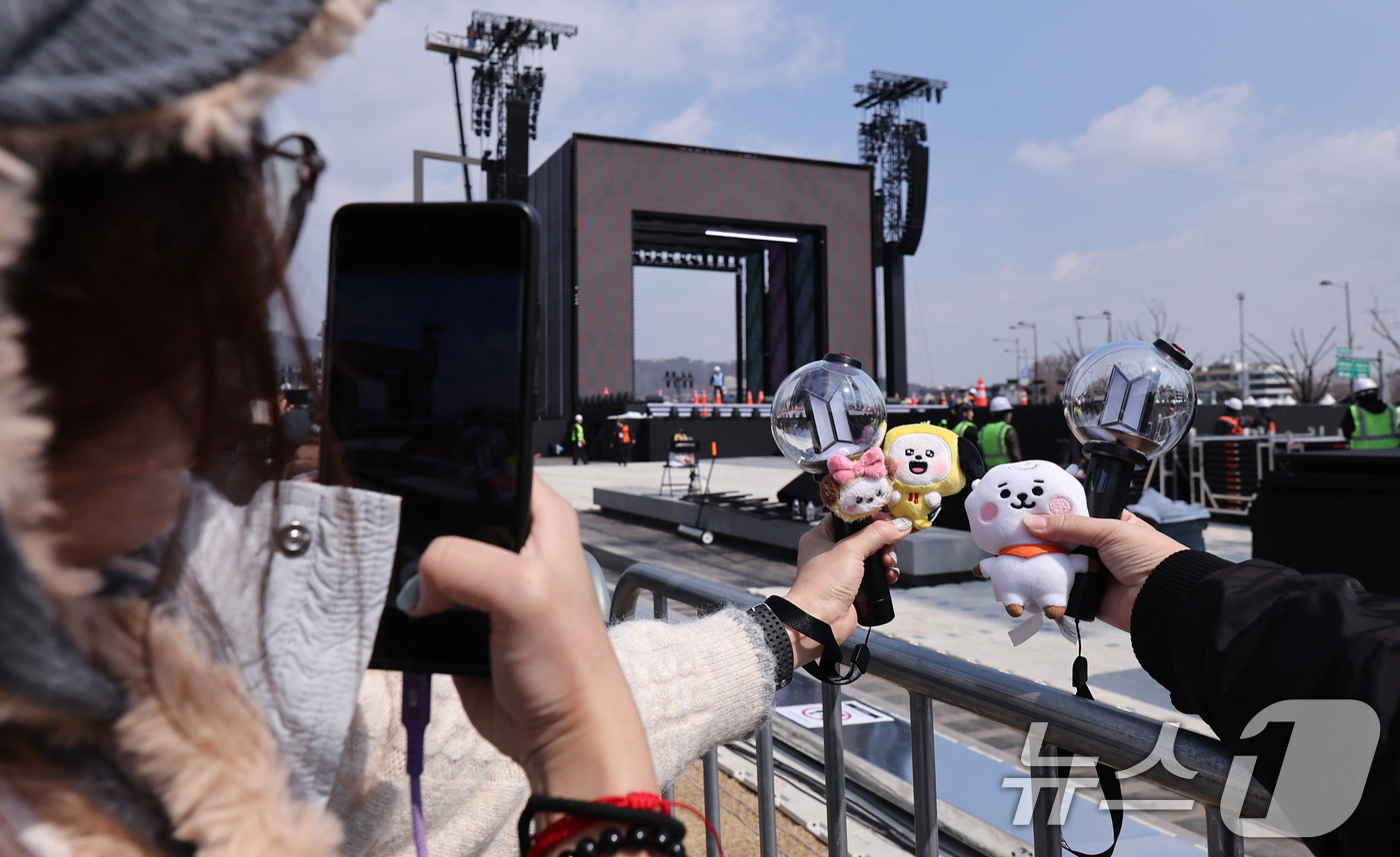 (서울=뉴스1) 박지혜 기자 = 방탄소년단(BTS) 완전체 컴백 공연을 하루 앞둔 20일 서울 광화문광장 공연장 앞에 대만에서 온 아미(ARMY·팬덤명)들이 굿즈를 들어보이고 있다 …