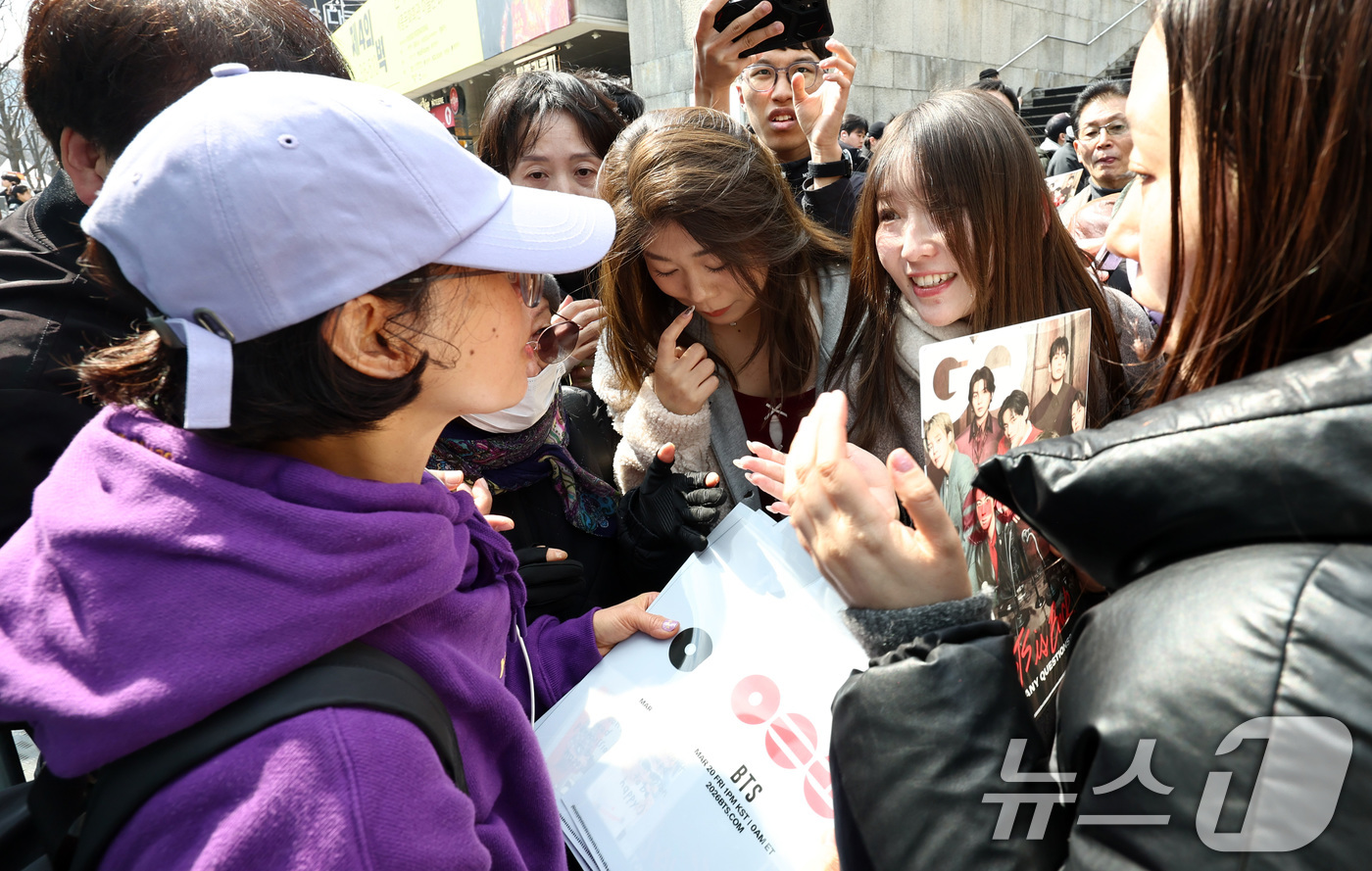 (서울=뉴스1) 최지환 기자 = 방탄소년단(BTS) 완전체 컴백 공연을 앞둔 20일 서울 광화문광장에서 BTS 팬이 포토카드를 비롯한 굿즈를 나눔하고 있다. 2026.3.20/뉴스 …