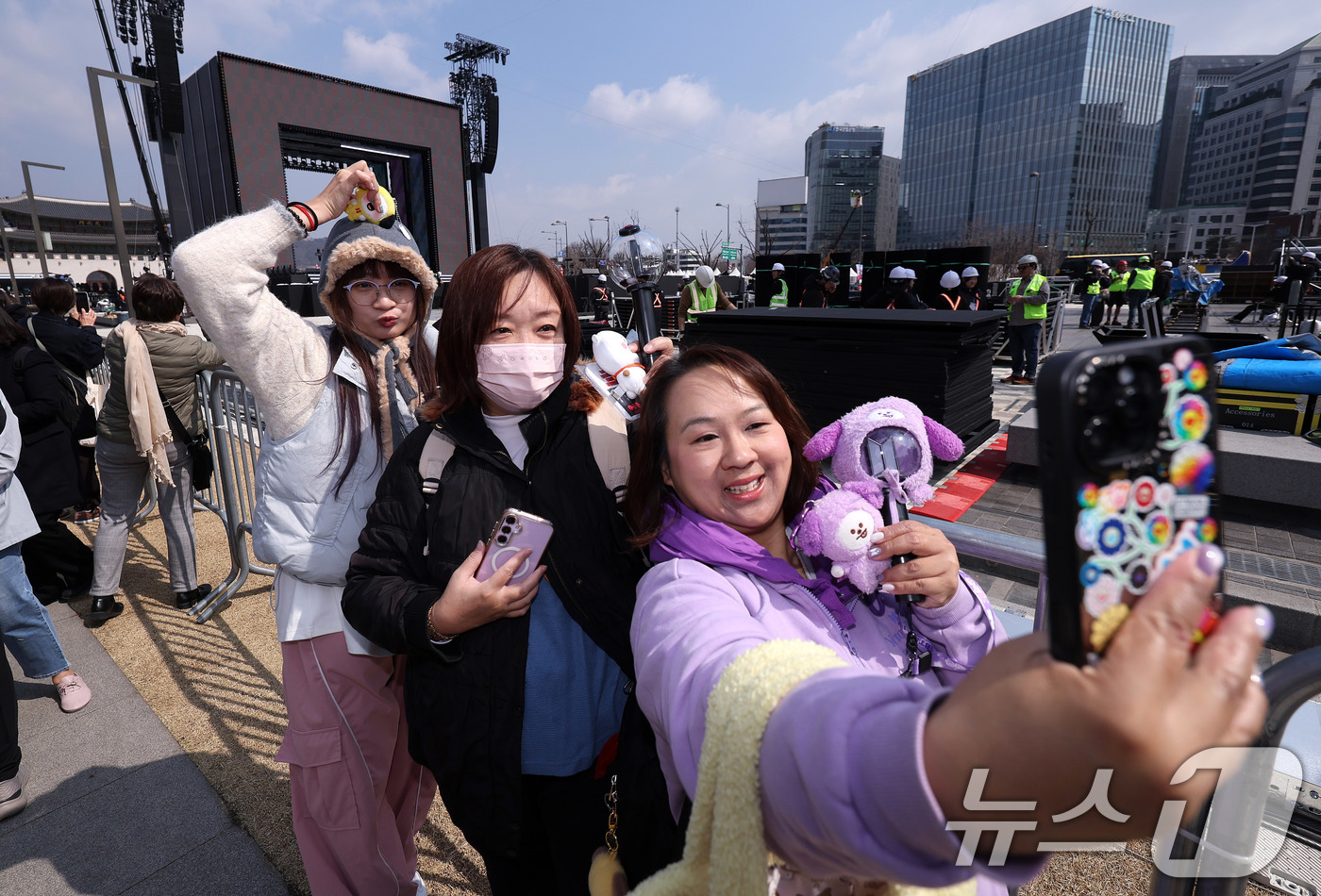 (서울=뉴스1) 박지혜 기자 = 방탄소년단(BTS) 완전체 컴백 공연을 하루 앞둔 20일 서울 광화문광장 공연장 앞에 대만에서 온 아미(ARMY·팬덤명)들이 기념 사진을 찍고 있다 …