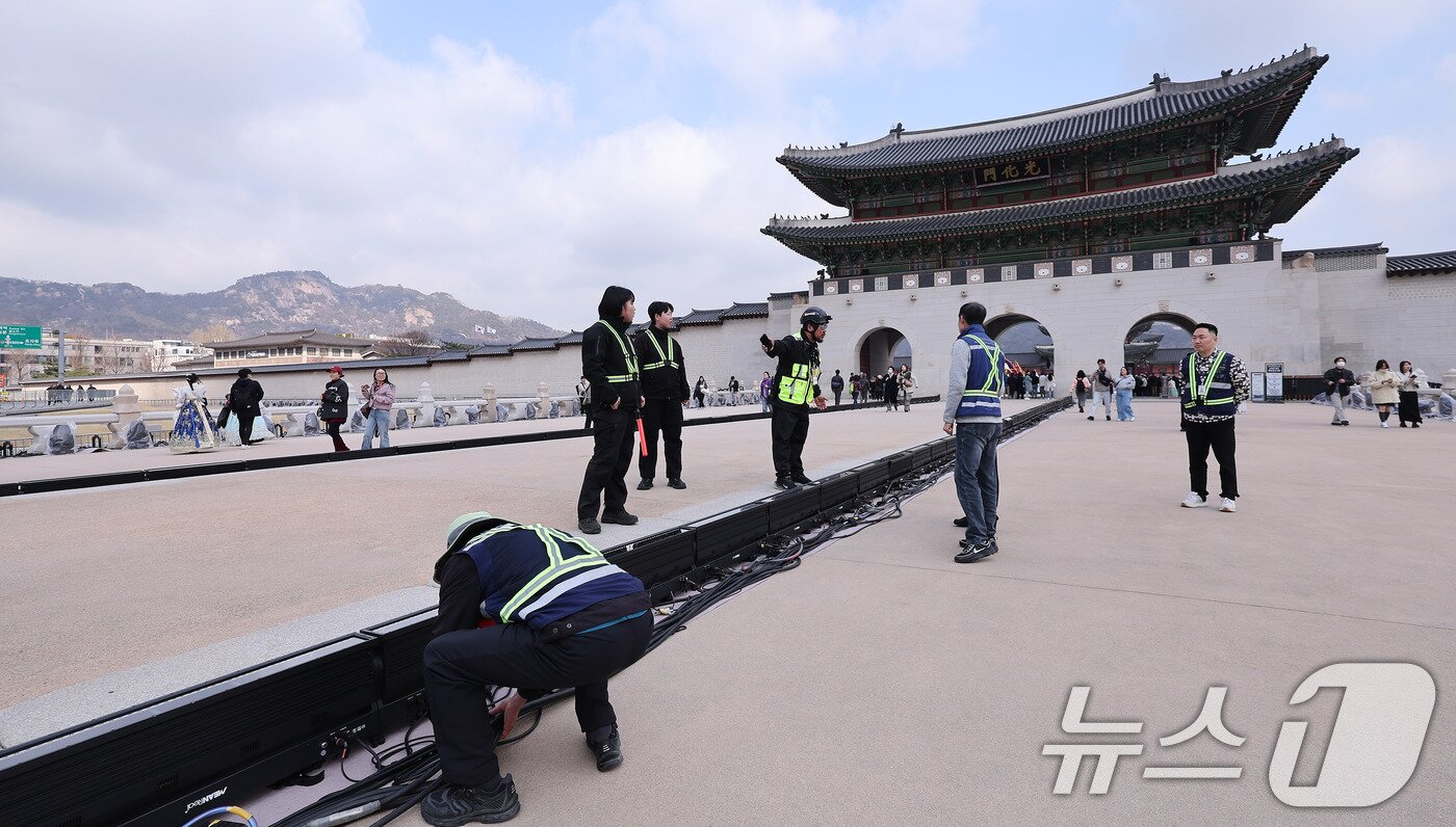 본문 이미지 - 방탄소년단(BTS) 완전체 컴백 공연을 하루 앞둔 20일 서울 광화문 월대에서 관계자가 설치된 공연 조명 주변을 지키고 있다. 2026.3.20 ⓒ 뉴스1 박지혜 기자
