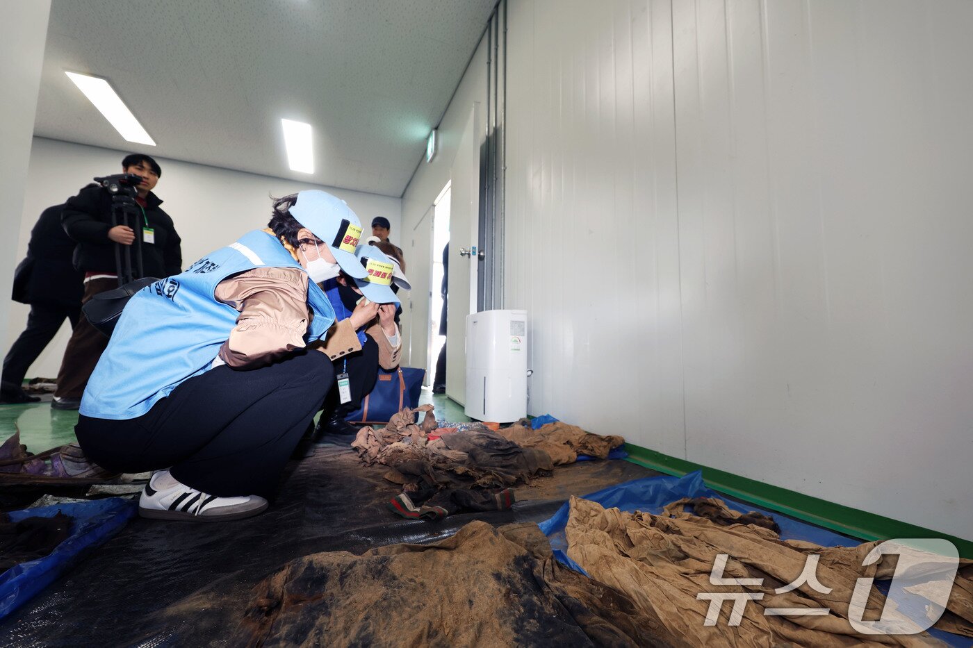 본문 이미지 - 20일 오후 전남 무안군 무안국제공항에서 여객기 참사 유가족들이 179명의 희생자들의 유류품이 보관된 장소에 주저 앉아 눈물 흘리고 있다. 2026.3.20 ⓒ 뉴스1 박지현 기자