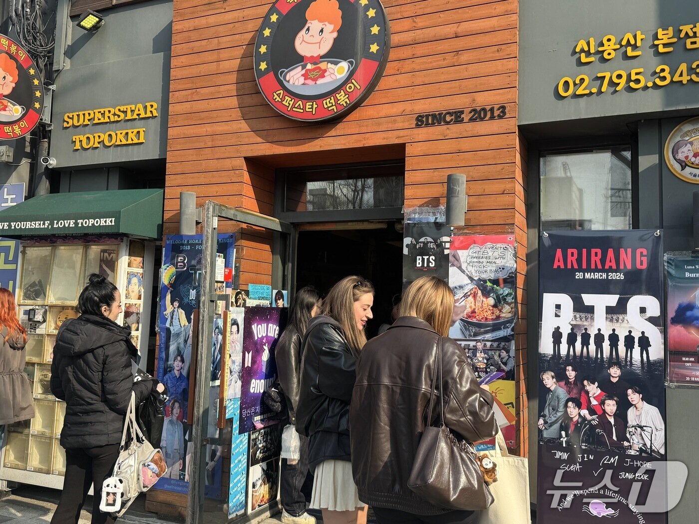 본문 이미지 - 'BTS 성지'로 알려진 서울 용산구의 한 떡볶이집 앞에서 해외 BTS 팬들이 모여 있다. 2026.3.20 ⓒ 뉴스1 권준언 기자
