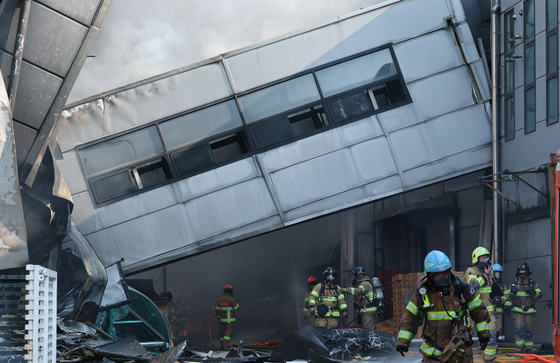 붕괴된 건물 아래서 화재 진화