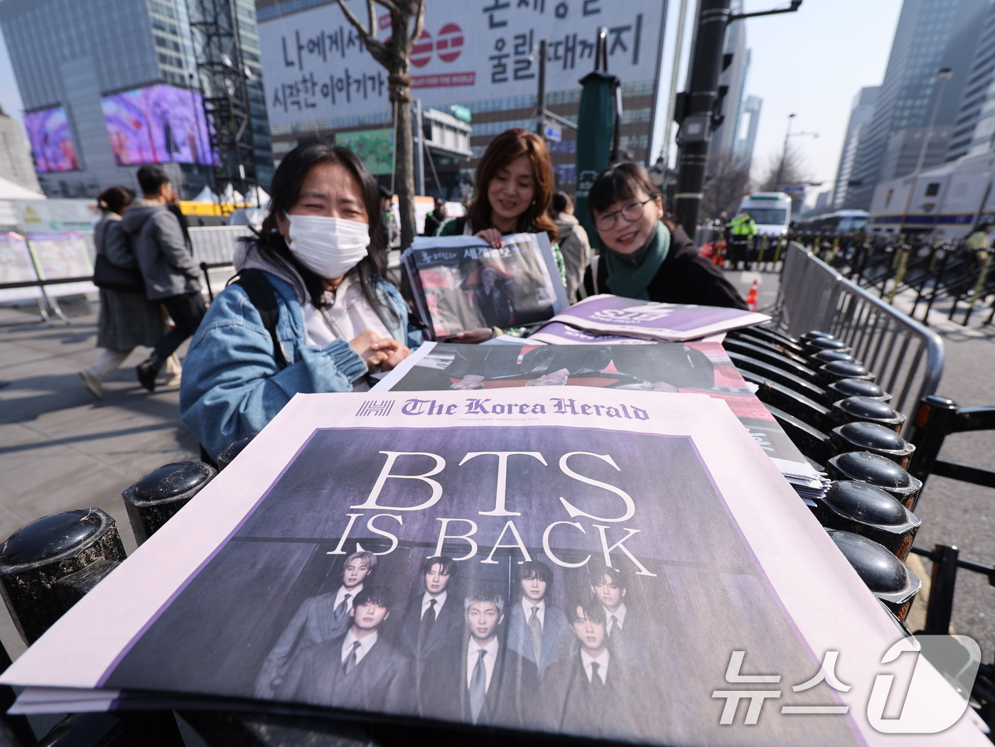 (서울=뉴스1) 박지혜 기자 = 방탄소년단(BTS) 컴백 공연일인 21일 오전 서울 광화문광장에서 외국인 관광객이 주요 일간지들이 발행한 BTS 관련 호외를 받고 있다. 2026. …