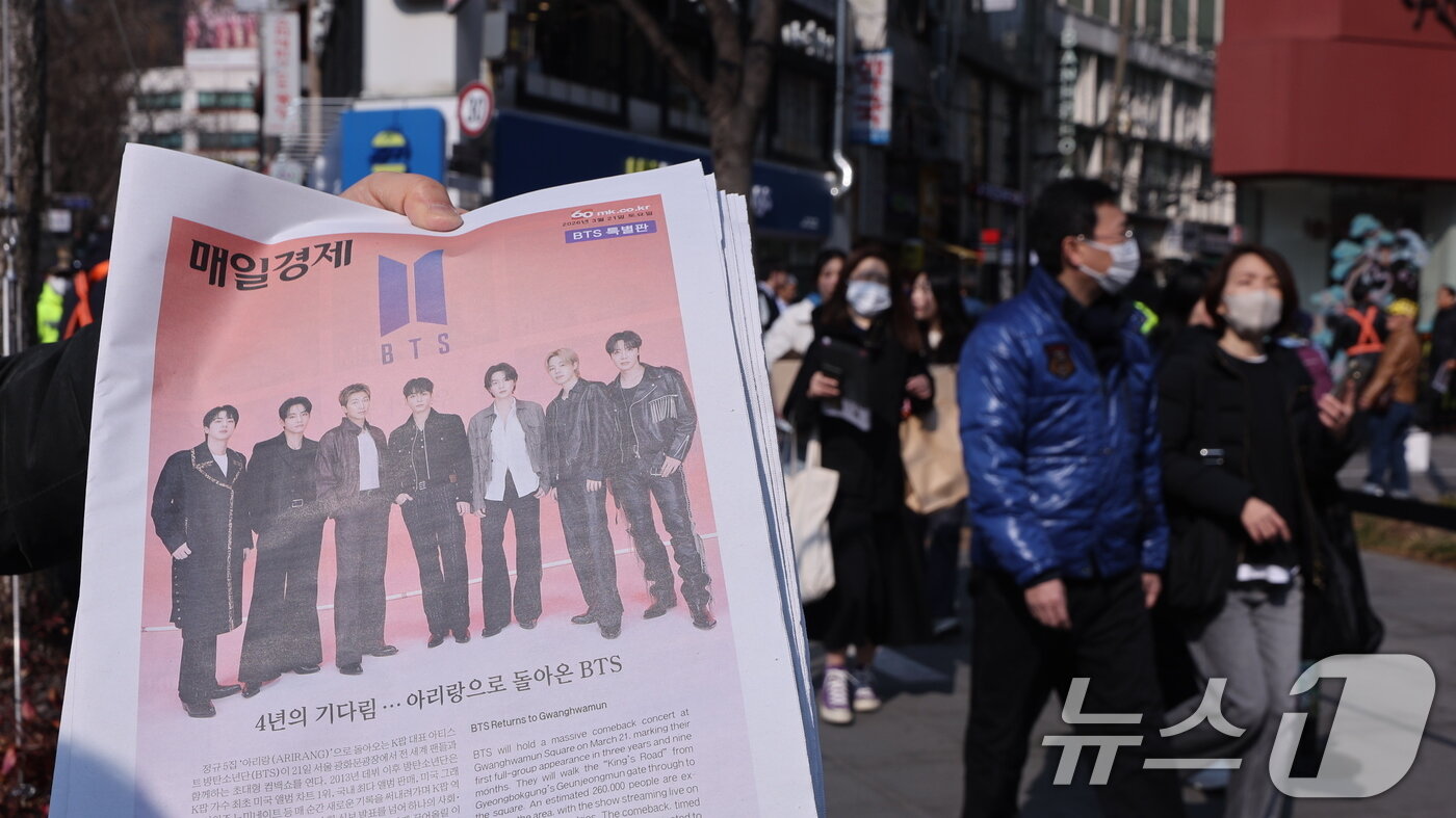 본문 이미지 - 방탄소년단(BTS) 컴백 공연일인 21일 오전 서울 광화문광장에서 주요 일간지들이 발행한 BTS 관련 호외를 관계자가 배포하고 있다. 2026.3.212026.3.21 ⓒ 뉴스1 박지혜 기자