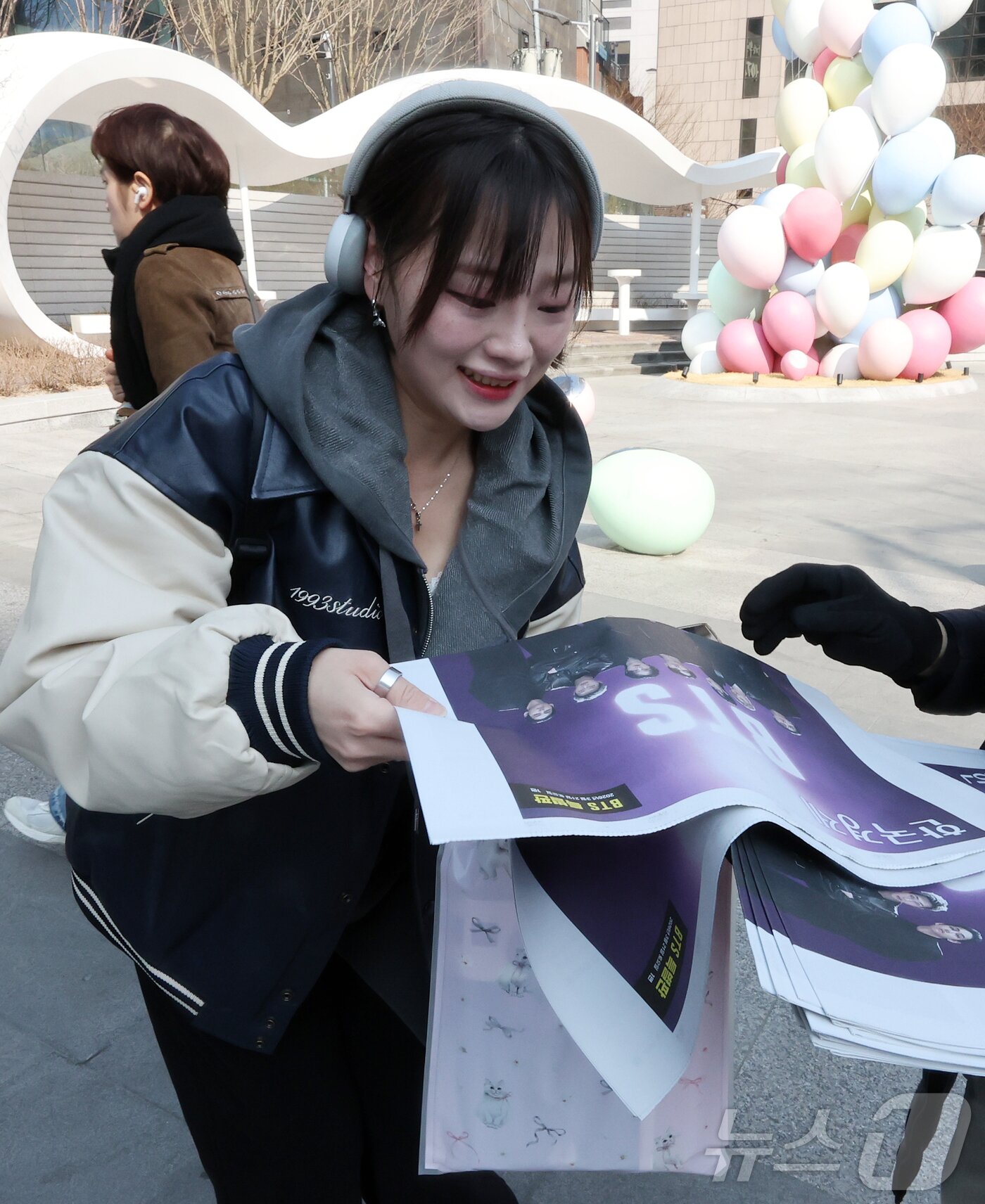 본문 이미지 - 방탄소년단(BTS) 컴백 공연일인 21일 오전 서울 을지로입구역에서 한 외국인 관광객이 주요 일간지가 발행한 BTS 특별판을 받고 있다. 2026.3.21 ⓒ 뉴스1 김진환 기자