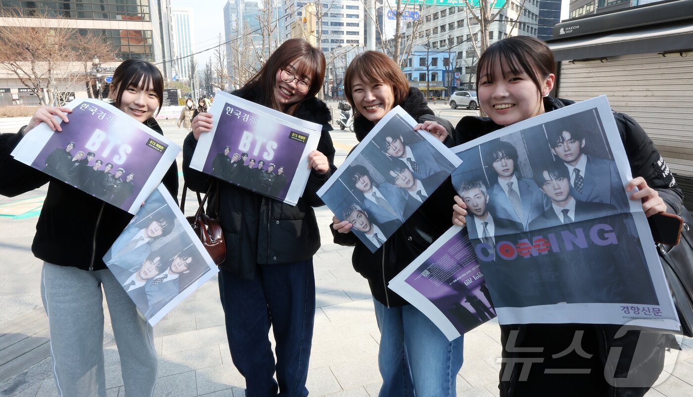 본문 이미지 - 방탄소년단(BTS) 컴백 공연일인 21일 오전 서울 을지로입구역에서 일본인 관광객들이 주요 일간지들이 발행한 BTS 특별판을 들어보이고 있다. 2026.3.21 ⓒ 뉴스1 김진환 기자