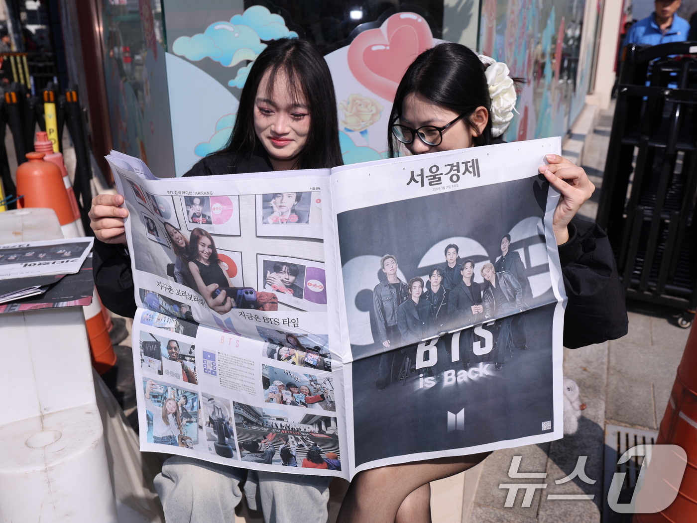 (서울=뉴스1) 박지혜 기자 = 방탄소년단(BTS) 컴백 공연일인 21일 오전 서울 광화문광장에서 일본인 관광객들이 주요 일간지들이 발행한 BTS 특별판을 보고 있다. 2026.3 …