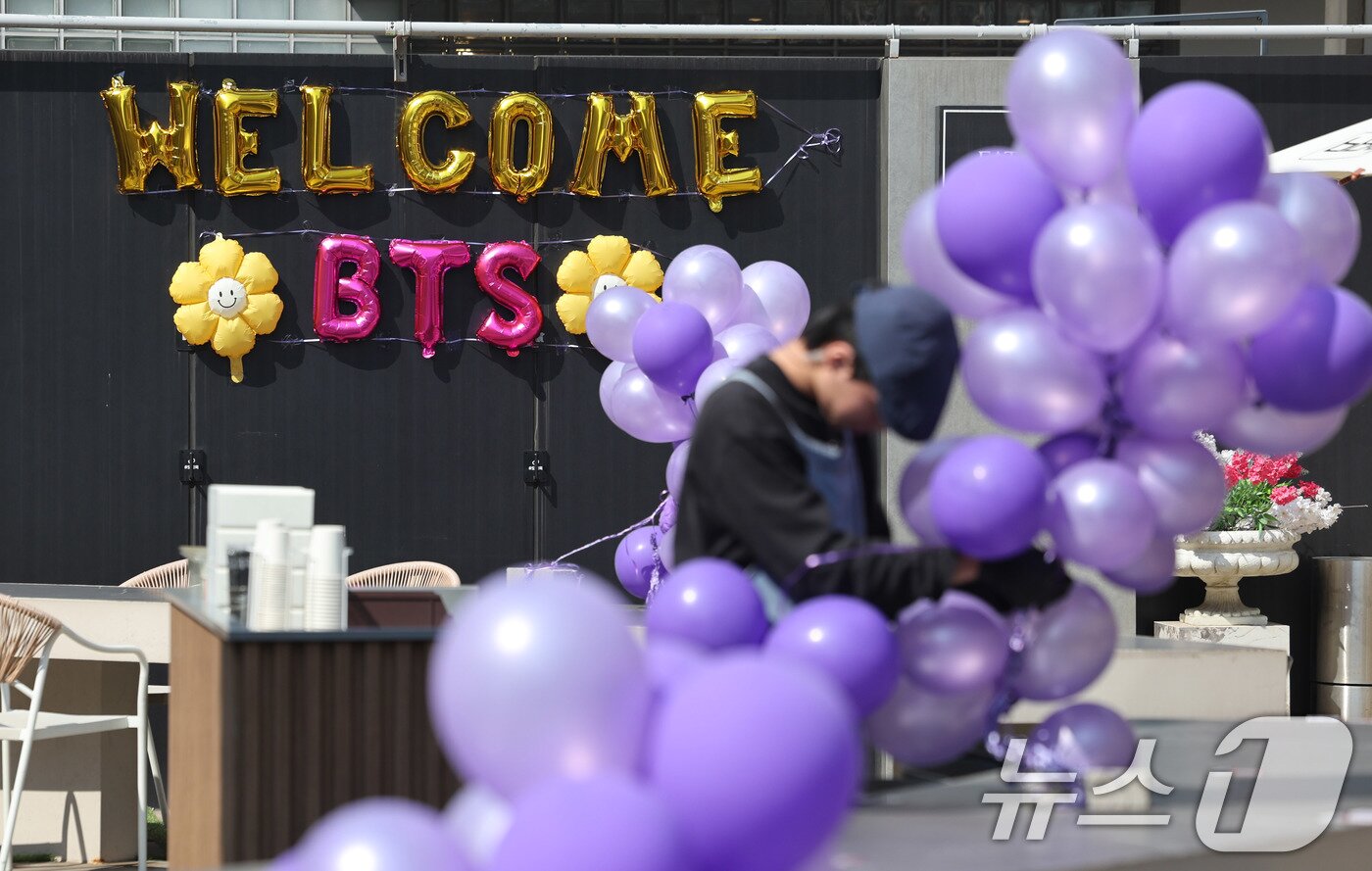 본문 이미지 - 방탄소년단(BTS) 컴백 공연이 열리는 21일 서울 종로구 광화문광장 인근 매장에서 직원이 보라색 풍선과 리본으로 매장을 장식하며 아미(BTS 팬덤)들을 맞을 준비를 하고 있다. 2026.3.21 ⓒ 뉴스1 박지혜 기자