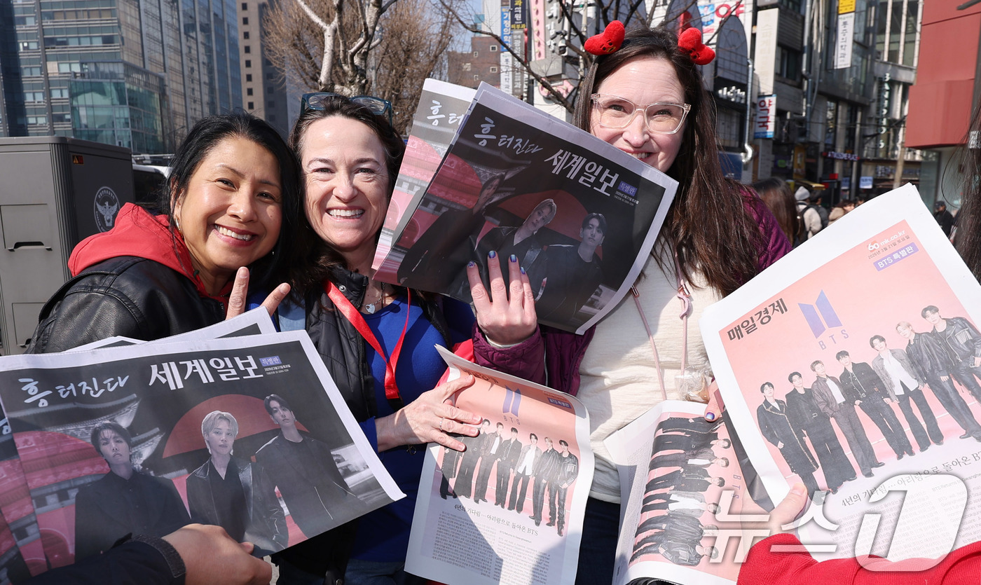 (서울=뉴스1) 박지혜 기자 = 방탄소년단(BTS) 컴백 공연일인 21일 오전 서울 광화문광장 인근에서 외국인 관광객이 BTS 관련 특별판을 들고 기념촬영을 하고 있다. 2026. …