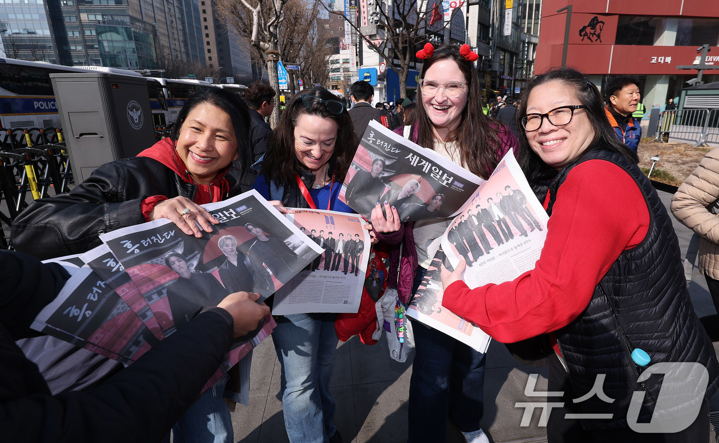 (서울=뉴스1) 박지혜 기자 = 방탄소년단(BTS) 컴백 공연일인 21일 오전 서울 광화문광장 인근에서 외국인 관광객들이 일간지들이 배포한 BTS 관련 특별판을 들고 있다. 202 …