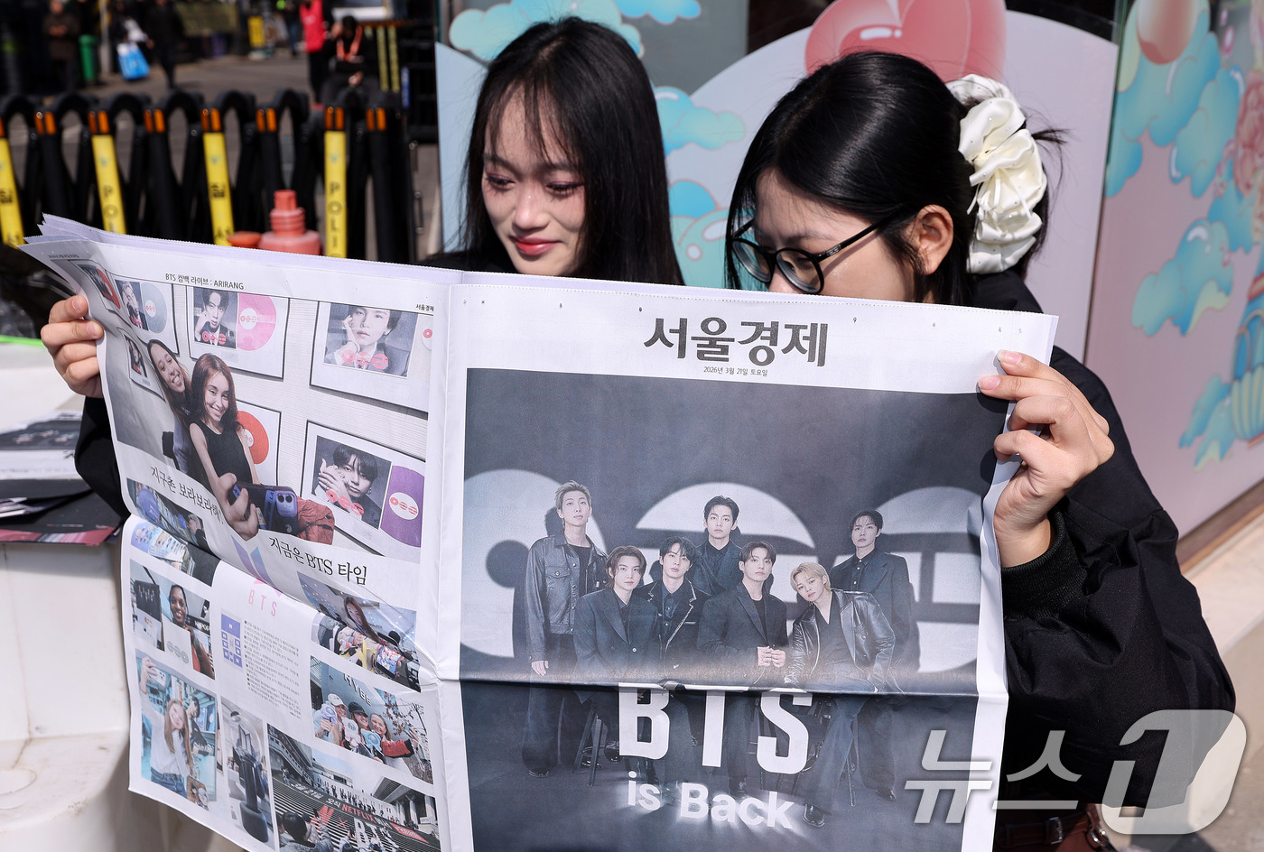 (서울=뉴스1) 박지혜 기자 = 방탄소년단(BTS) 컴백 공연일인 21일 오전 서울 광화문광장 인근에서 외국인 관광객이 주요 일간지의 BTS 관련 호외를 보고 있다. 2026.3. …