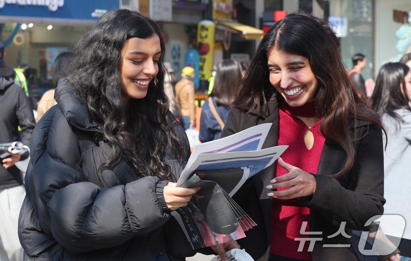 본문 이미지 - 방탄소년단(BTS) 컴백 공연일인 21일 오전 서울 광화문광장 인근에서 외국인 관광객이 주요 일간지의 BTS 관련 호외를 보고 있다. 2026.3.21 ⓒ 뉴스1 박지혜 기자