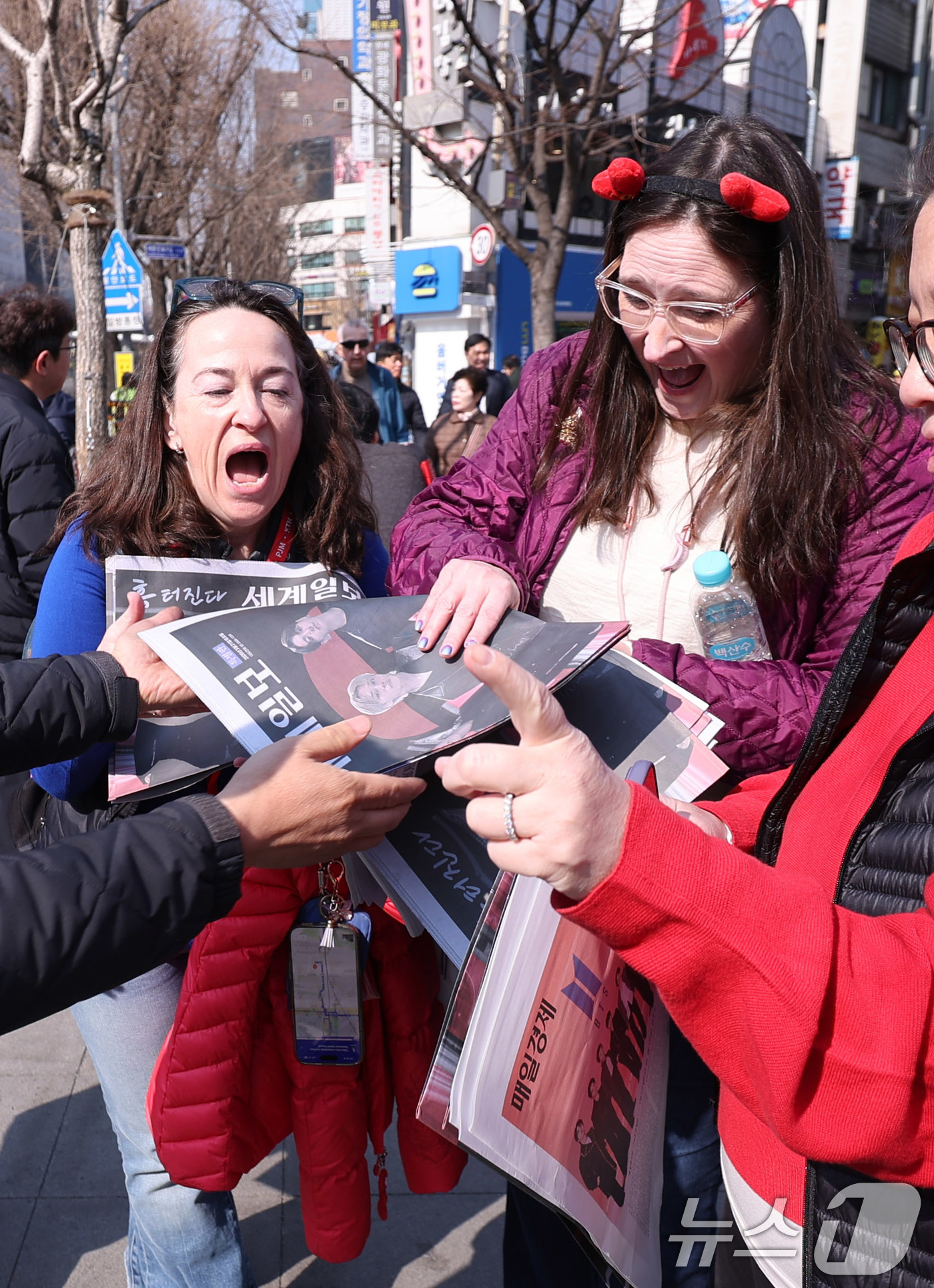 (서울=뉴스1) 박지혜 기자 = 방탄소년단(BTS) 컴백 공연일인 21일 오전 서울 광화문광장 인근에서 외국인 관광객들이 일간지들이 배포한 BTS 관련 특별판을 받고 있다. 202 …