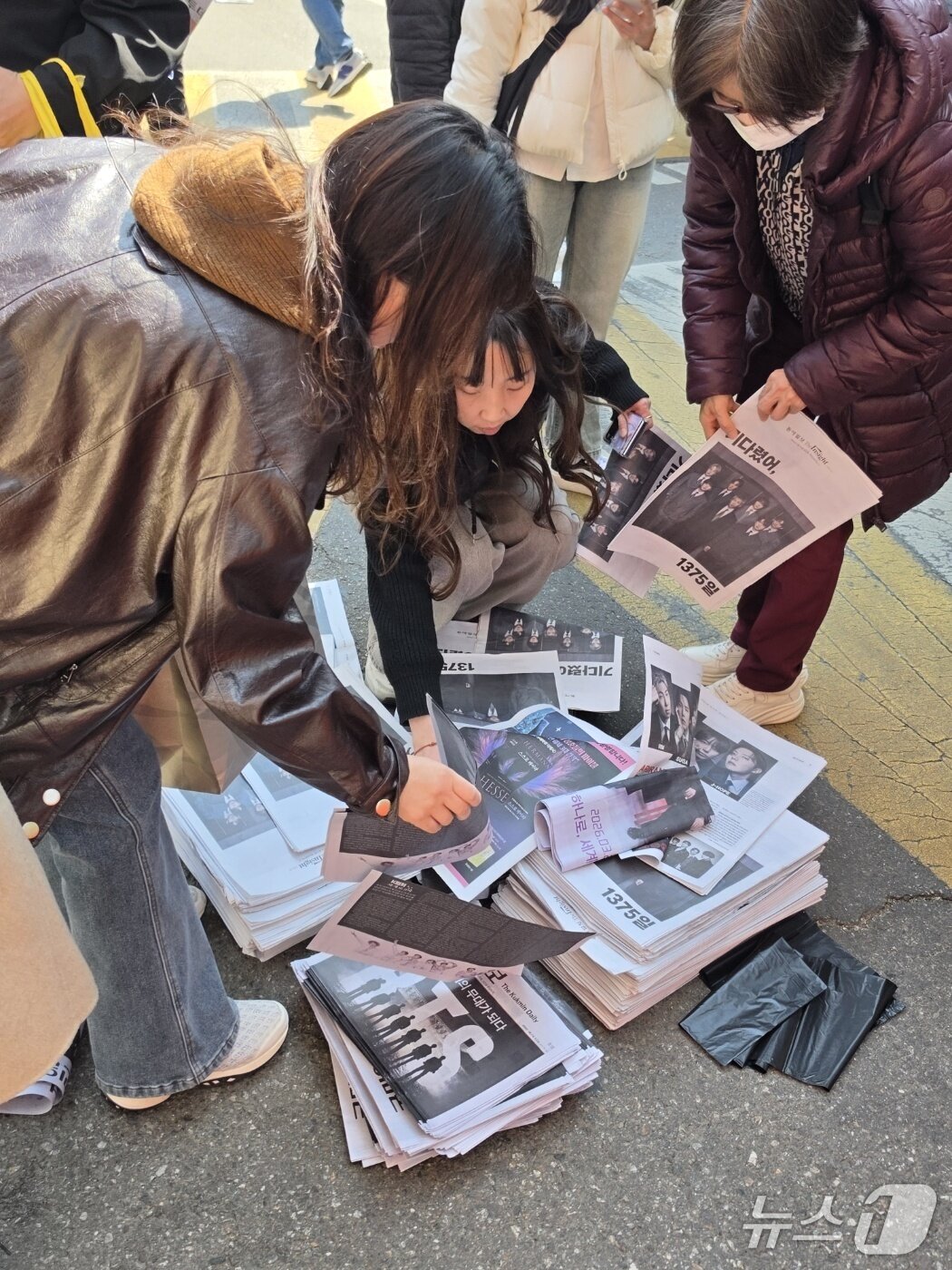 본문 이미지 - 그룹 방탄소년단(BTS) 컴백 공연일인 21일 오후 서울 광화문광장 인근에서 팬들이 일간지들이 배포한 BTS 관련 특별판을 가져가고 있다. ⓒ 뉴스1 안태현 기자