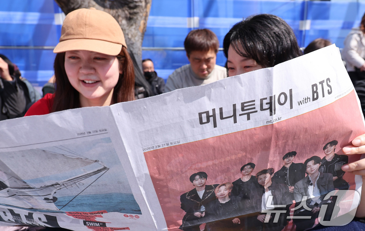 (서울=뉴스1) 박지혜 기자 = 방탄소년단(BTS) 컴백 공연일인 21일 오전 서울 광화문광장 인근에서 외국인 관광객이 주요 신문사의 BTS 관련 호외를 보고 있다. 2026.3. …