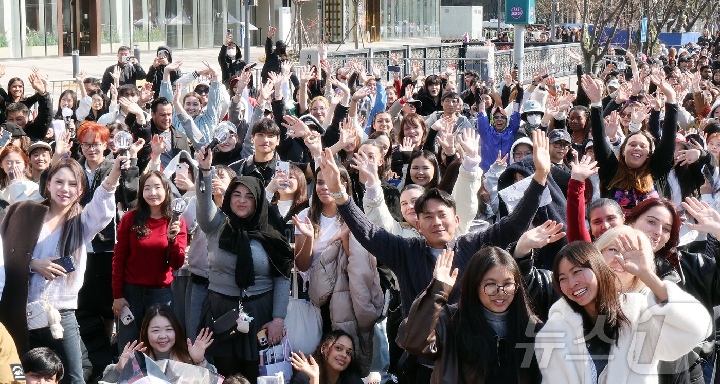 본문 이미지 - 방탄소년단(BTS) 컴백 공연일인 21일 오전 서울 종로구 광화문광장에서 팬들이 공연 시작을 기다리며 취재진을 향해 환호하고 있다. 2026.3.21 ⓒ 뉴스1 김진환 기자