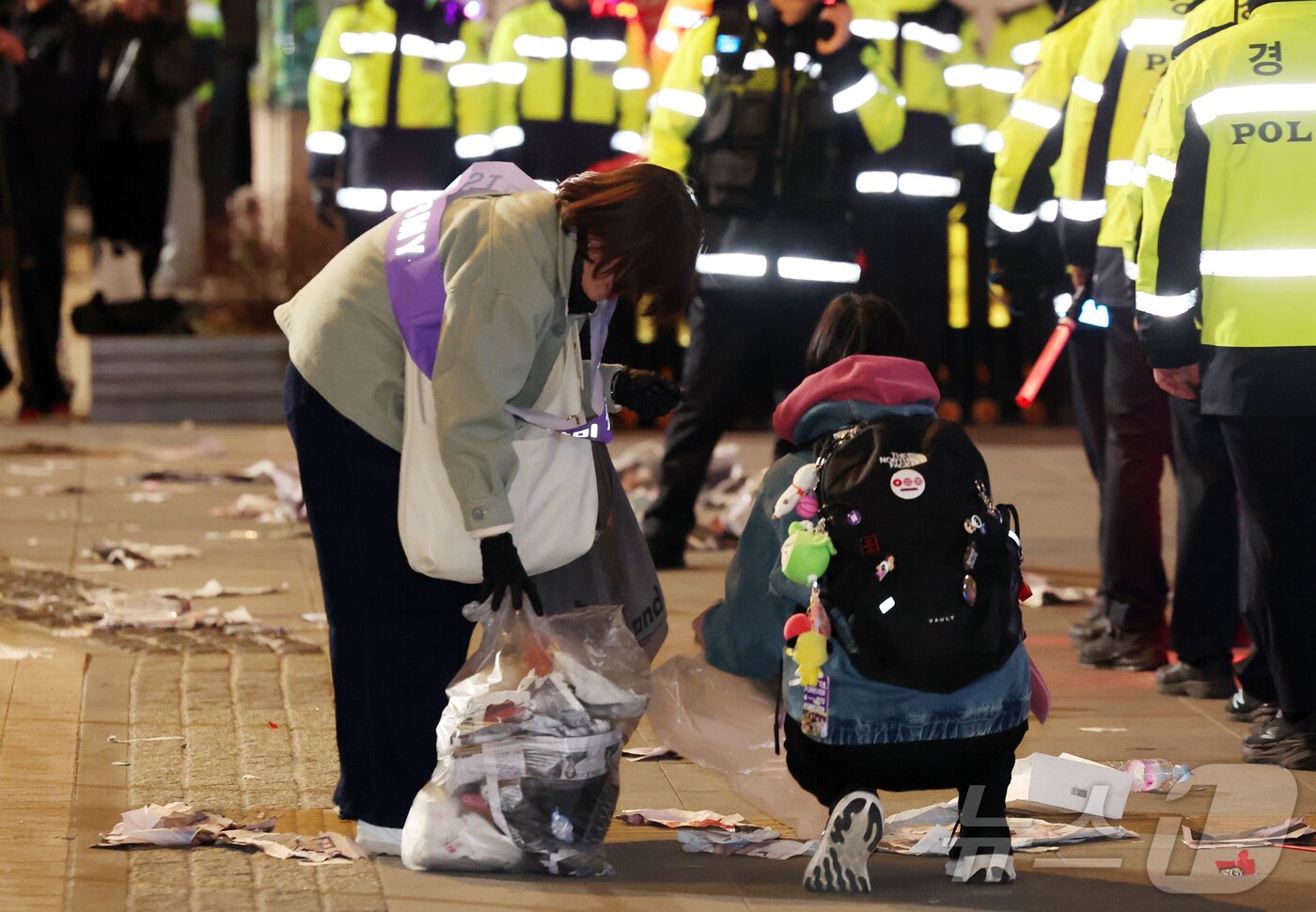 본문 이미지 - 21일 오후 서울 종로구 광화문광장에서 열린 'BTS 컴백 라이브: 아리랑'이 끝난 후 한 아미 자원봉사단원이 쓰레기를 치우고 있다. 2026.3.21 ⓒ 뉴스1 김진환 기자