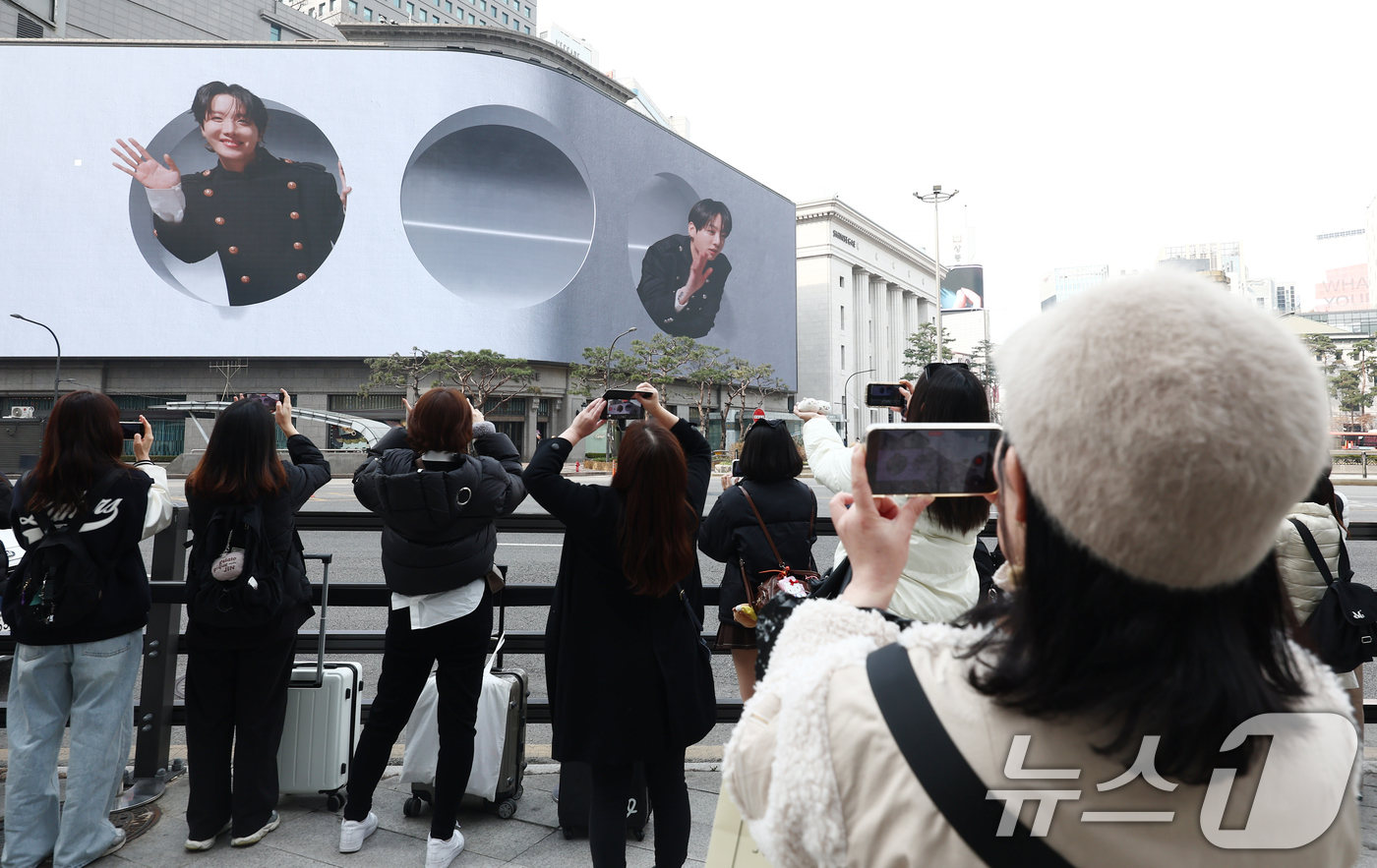 (서울=뉴스1) 김민지 기자 = 방탄소년단(BTS) 컴백 공연 다음 날인 22일 오전 서울 중구 신세계백화점 인근에서 방탄소년단의 팬클럽 ARMY가 송출되는 BTS의 모습을 사진 …