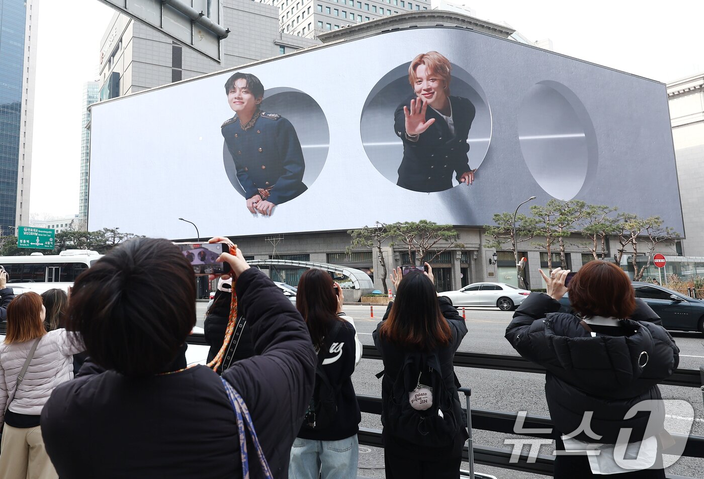 본문 이미지 - 방탄소년단(BTS) 컴백 공연 다음 날인 22일 오전 서울 중구 신세계백화점 인근에서 방탄소년단의 팬클럽 ARMY가 송출되는 BTS의 모습을 사진 찍고 있다. ⓒ 뉴스1 김민지 기자