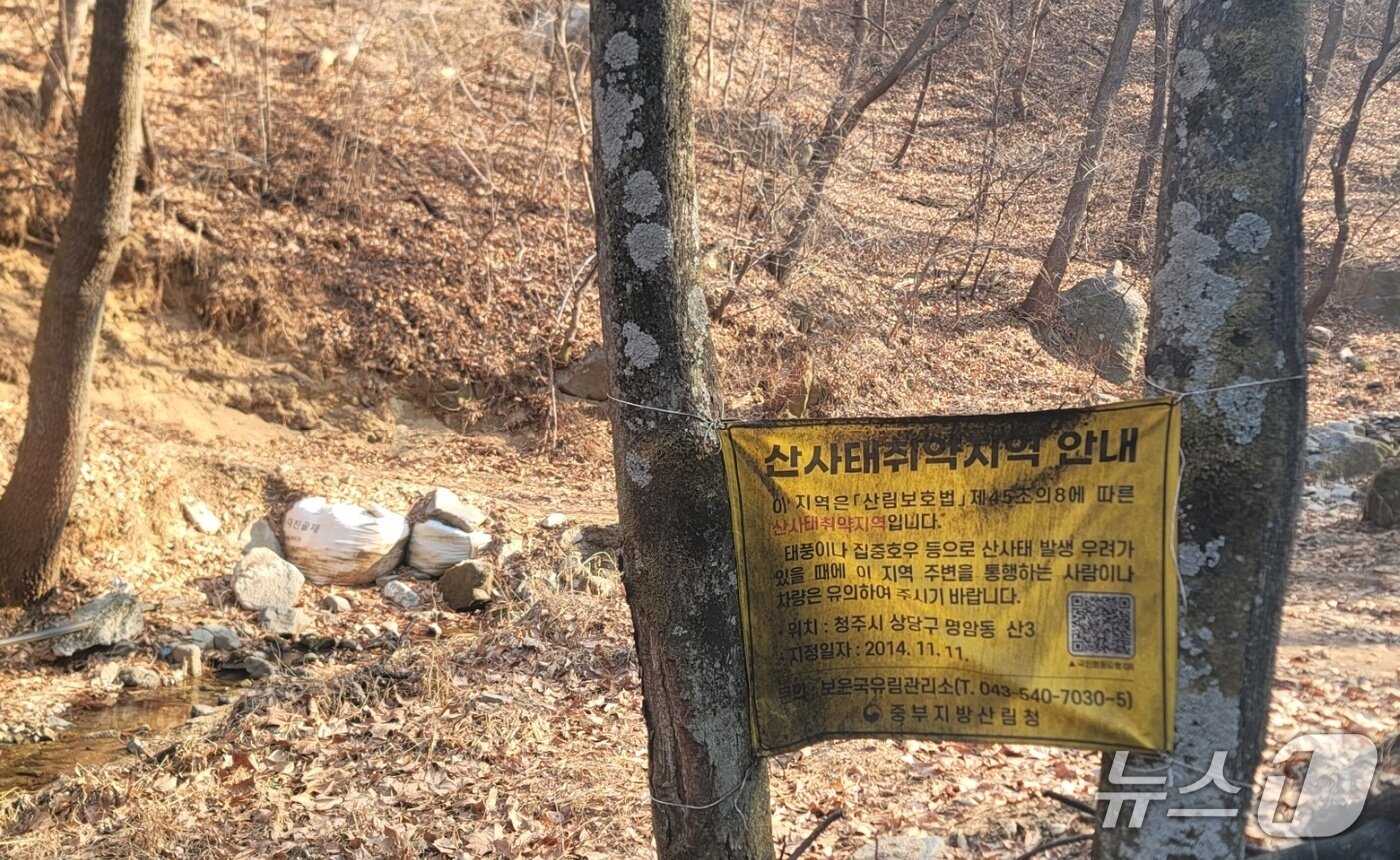 본문 이미지 - 상당산성 도시생태 휴식공간 조성사업장 인근 게시된 산사태취약지역 지정 현수막.2026.3.22./뉴스1 임양규 기자