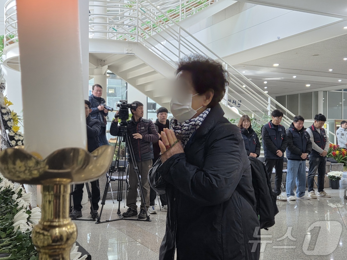 (대전=뉴스1) 김종서 기자 = 22일 오전 대전시청 1층에 마련된 대전 공장 화재 사망자 합동분향소에서 유족이 손을 모아 기도하고 있다. 2026.3.22/뉴스1