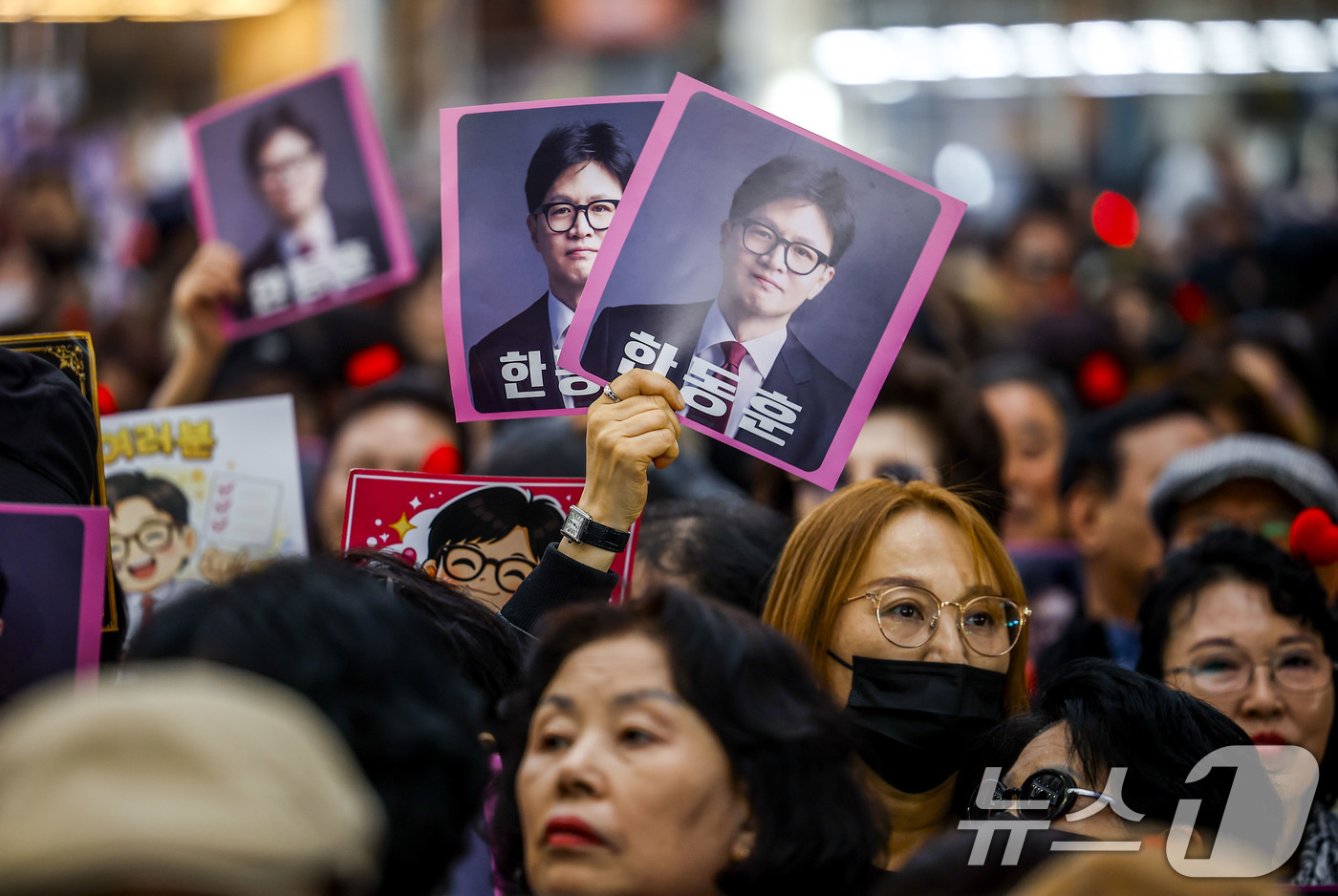 (서울=뉴스1) 최지환 기자 = 22일 서울 동대문구 경동시장에서 한동훈 전 국민의힘 대표 지지자들이 피켓을 들고 있다. (공동취재) 2026.3.22/뉴스1