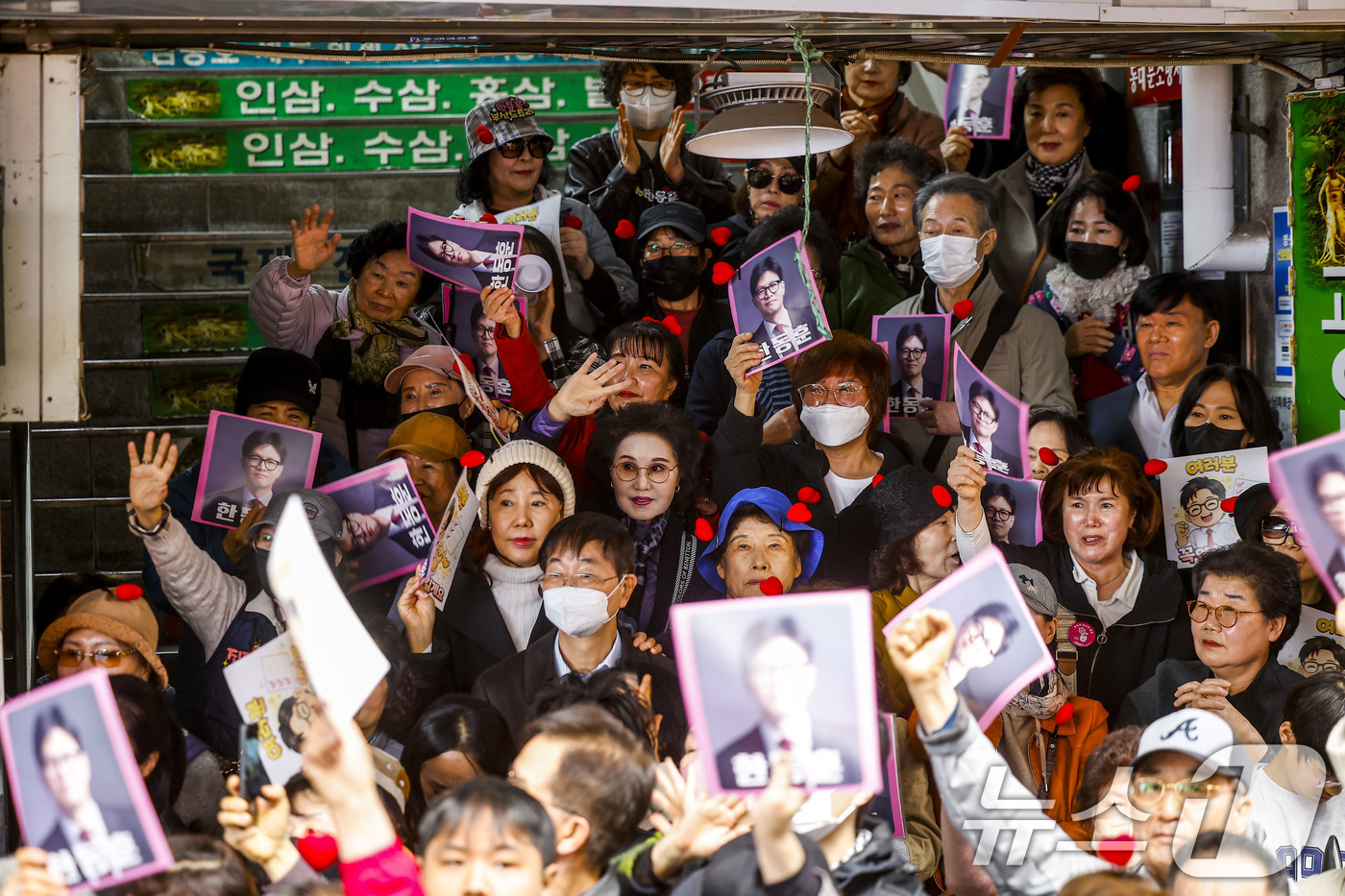 (서울=뉴스1) 최지환 기자 = 22일 서울 동대문구 경동시장에서 한동훈 전 국민의힘 대표 지지자들이 피켓을 들고 있다. (공동취재) 2026.3.22/뉴스1