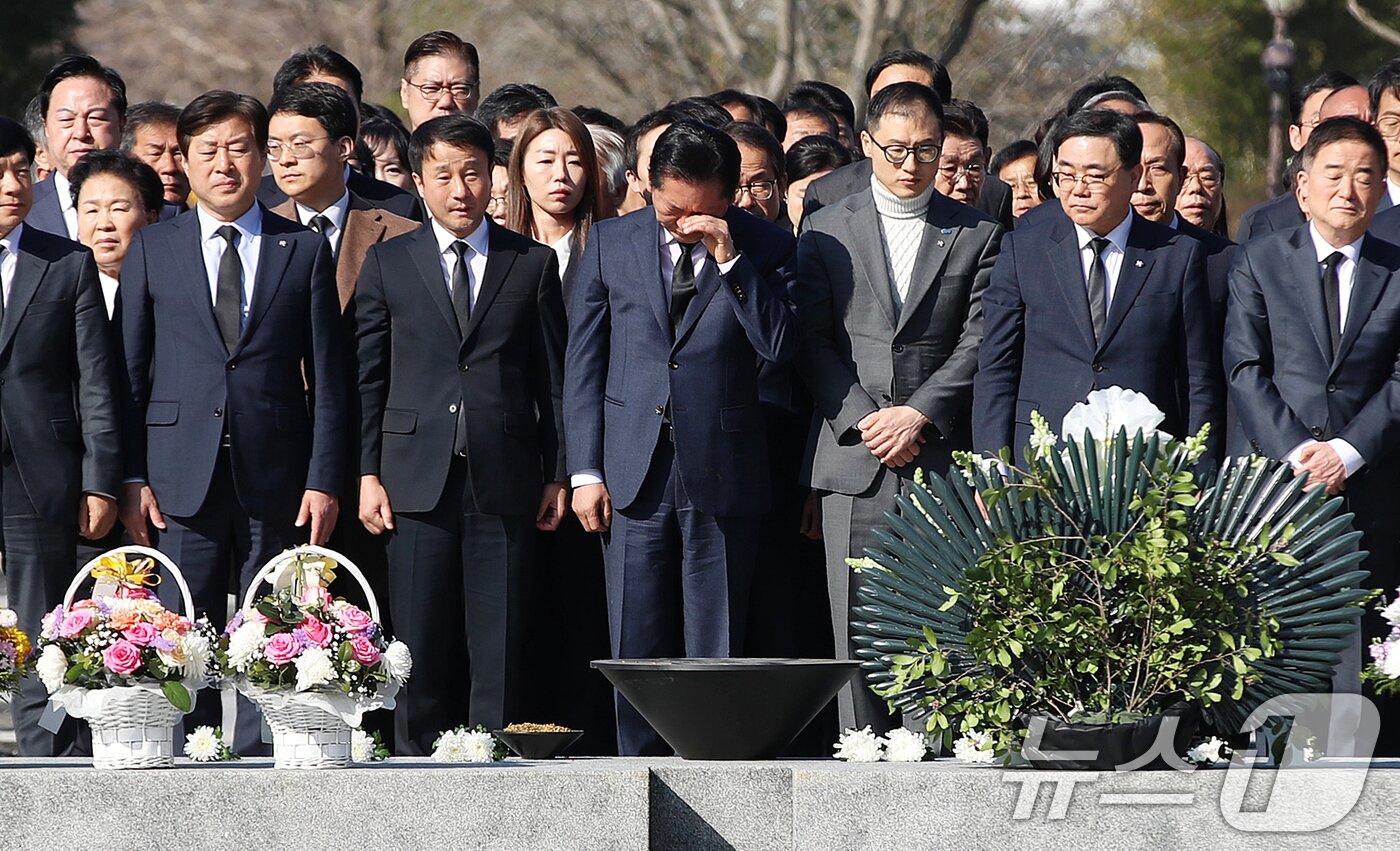 본문 이미지 - 정청래 더불어민주당 대표가 23일 오전 경남 김해 진영읍 봉하마을을 찾아 고 노무현 전 대통령 묘역을 참배하며 손으로 얼굴을 닦고 있다. 2026.3.23 ⓒ 뉴스1 윤일지 기자