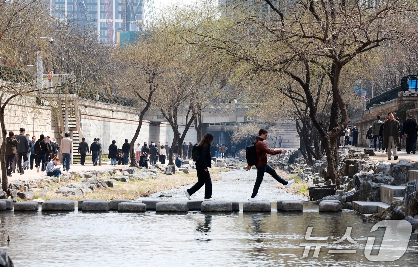 본문 이미지 - 완연한 봄 날씨를 보인 23일 서울 종로구 청계천을 찾은 관광객들이 산책을 하고 있다. 2026.3.23 ⓒ 뉴스1 이호윤 기자