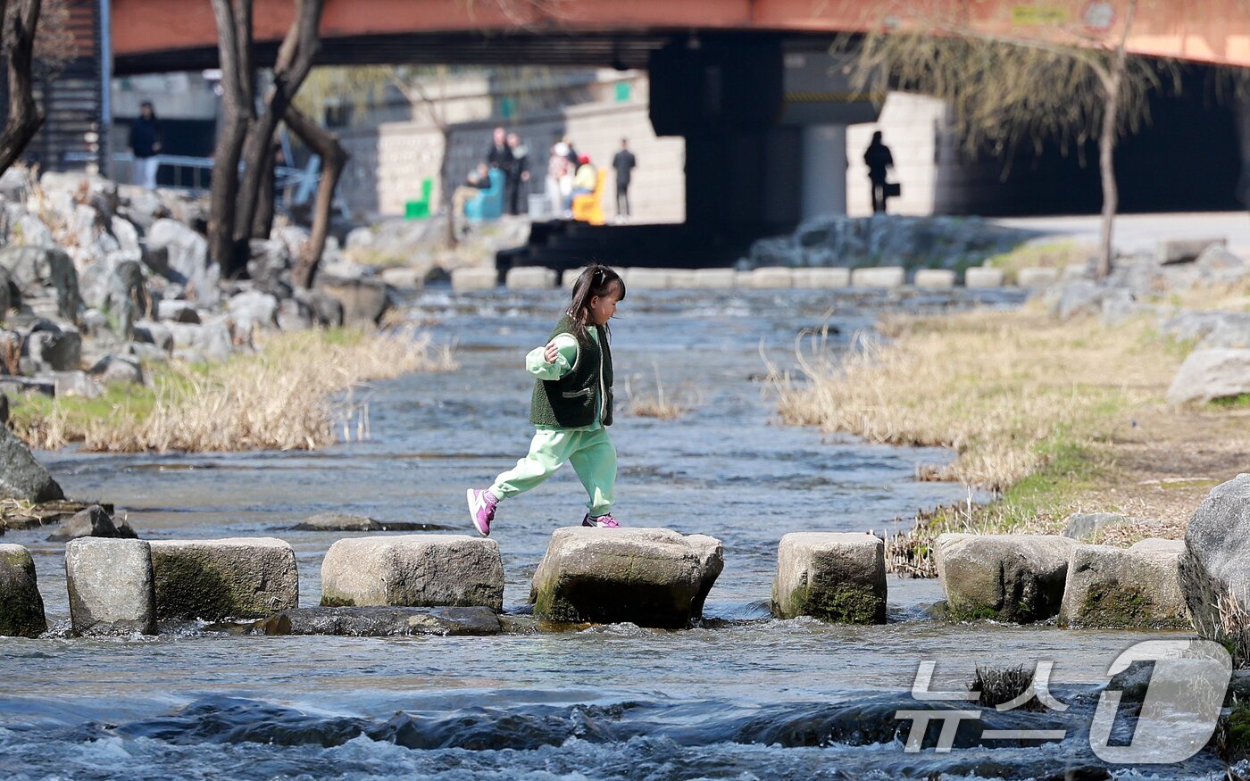 본문 이미지 - 완연한 봄 날씨를 보인 23일 서울 종로구 청계천을 찾은 아이가 산책을 하고 있다. 2026.3.23 ⓒ 뉴스1 이호윤 기자