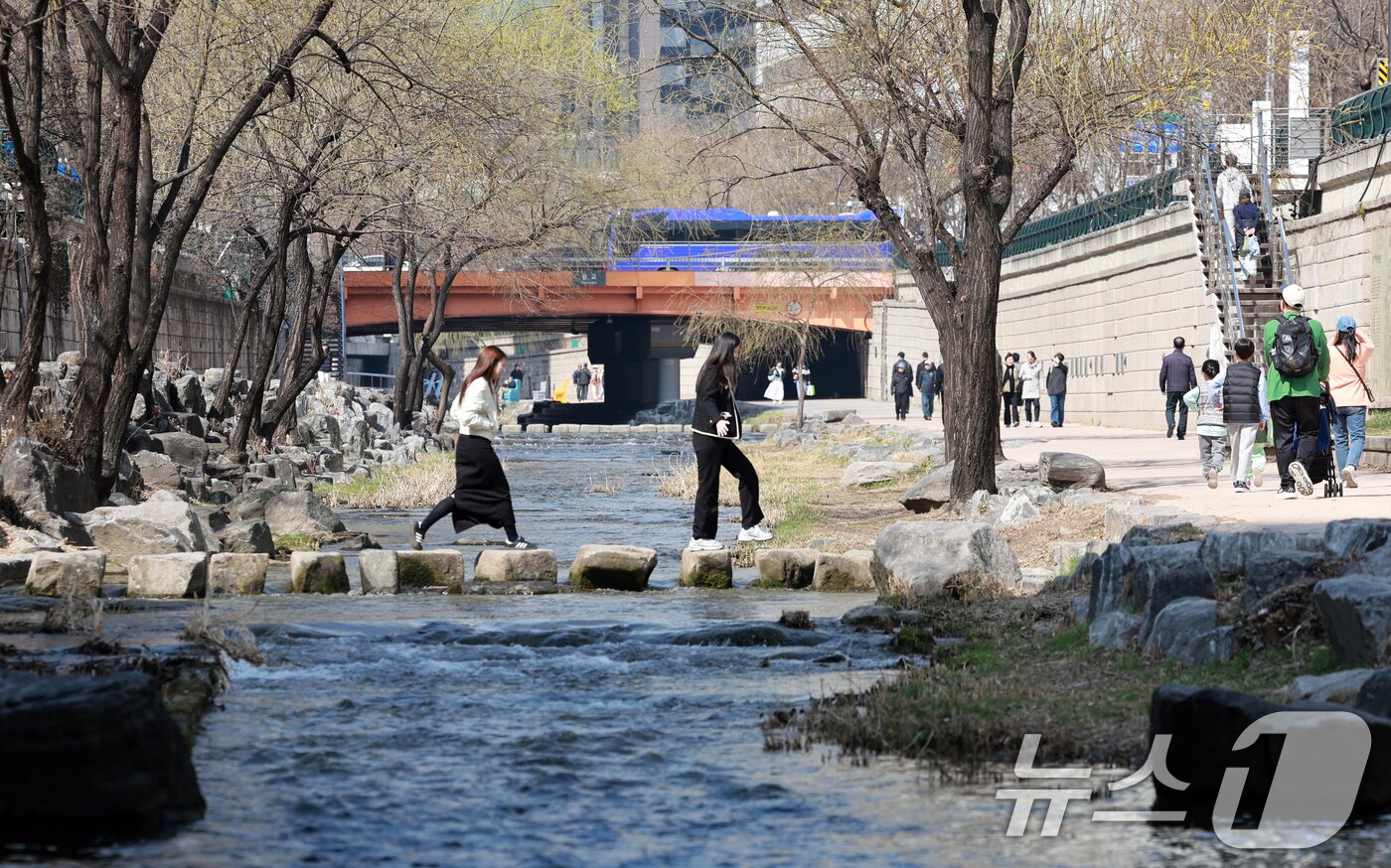 본문 이미지 - 완연한 봄 날씨를 보인 23일 서울 종로구 청계천을 찾은 시민들이 산책을 하고 있다. 2026.3.23 ⓒ 뉴스1 이호윤 기자