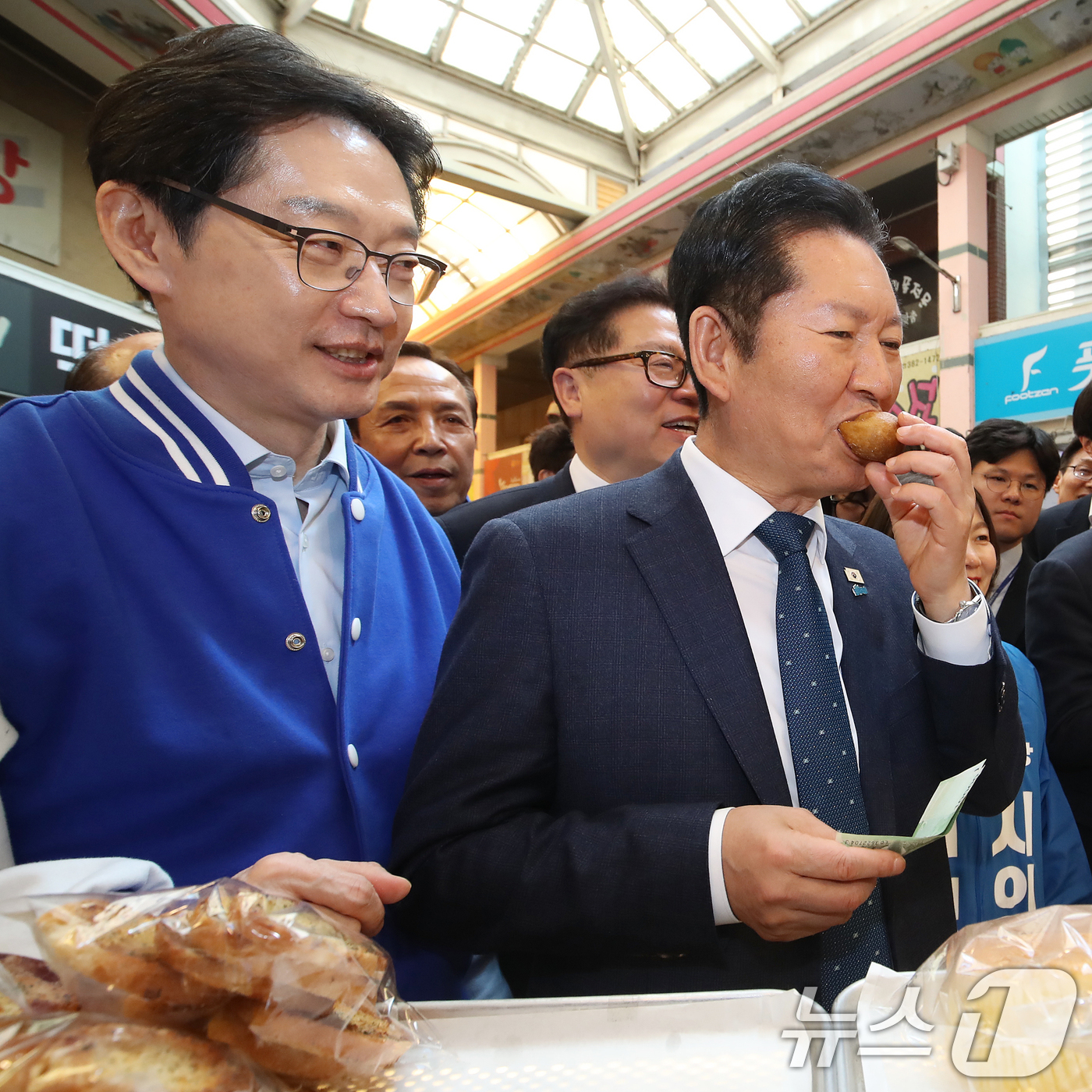 (양산=뉴스1) 윤일지 기자 = 정청래 더불어민주당 대표가 23일 오후 경남 양산 중부동 남부시장을 찾아 도넛을 맛보고 있다.  2026.3.23/뉴스1