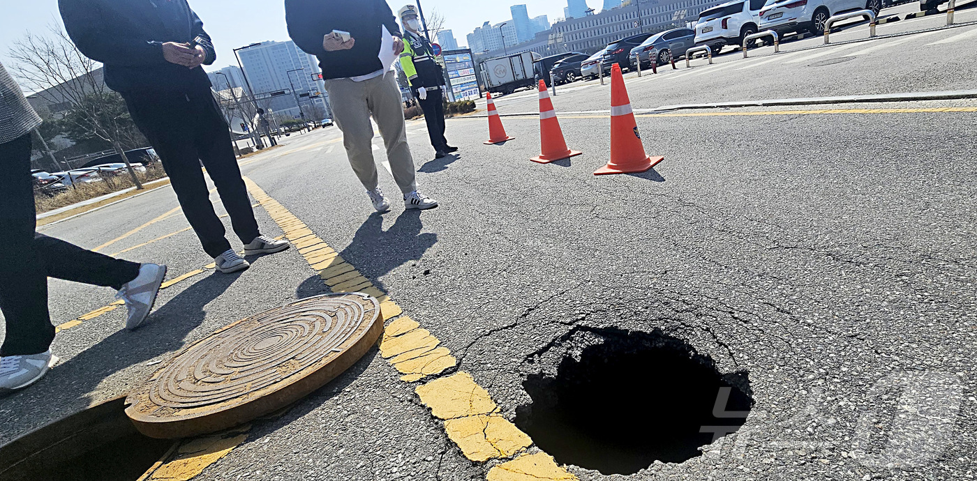 (세종=뉴스1) 김기남 기자 = 23일 오후 세종시 어진동 정부세종청사 인근 도로에 씽크홀이 발생하여 경찰이 도로를 통제하며 세종시 관계 공무원들이 대책을 논의하고 있다. 2026 …