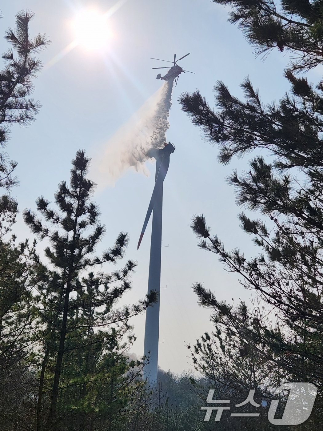 (영덕=뉴스1) 최창호 기자 = 23일 오후 1시 11분쯤 경북 영덕군 창포리 풍력발전단지 내 풍력발전기에서 불이나 산림진화 전문 헬기로 진화작업을 벌이고 있다.2026.3.23/ …