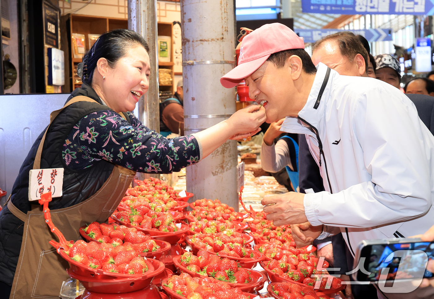 (서울=뉴스1) 이호윤 기자 = 오세훈 서울시장이 23일 서울 동대문구 경동시장에서 상인이 건네준 딸기를 맛보고 있다. 2026.3.23/뉴스1