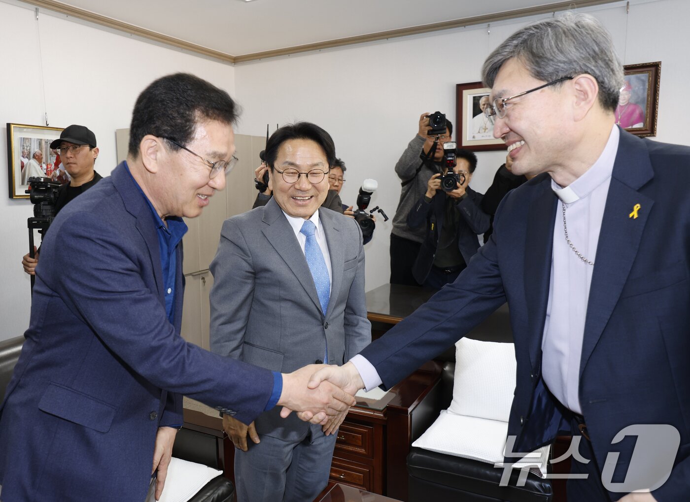 본문 이미지 - 강기정, 신정훈 더불어민주당 전남광주통합특별시장 후보가 23일 천주교 광주대교구를 방문해 옥현진 시몬 대주교와 악수를 나누고 있다. 2026.3.23 ⓒ 뉴스1 김태성 기자