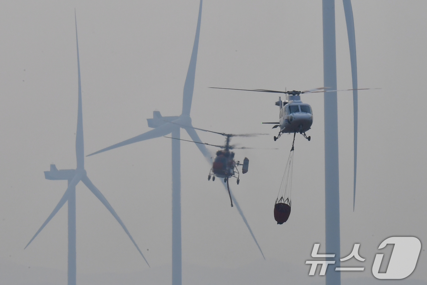 (영덕=뉴스1) 최창호 기자 = 23일 오후 경북 영덕군 창포리 풍력발전단지 내 풍력발전기에서 발생한 불을 끄기 위해 산림청, 소방, 인근 지자체 진화헬기들이 진화작업을 벌이고 있 …