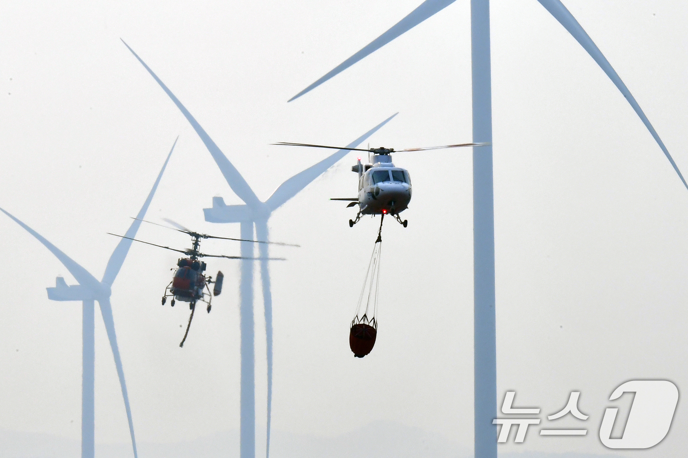 (영덕=뉴스1) 최창호 기자 = 23일 오후 경북 영덕군 창포리 풍력발전단지 내 풍력발전기에서 발생한 불을 끄기 위해 산림청, 소방, 인근 지자체 진화핼기들이 진화작업을 벌이고 있 …