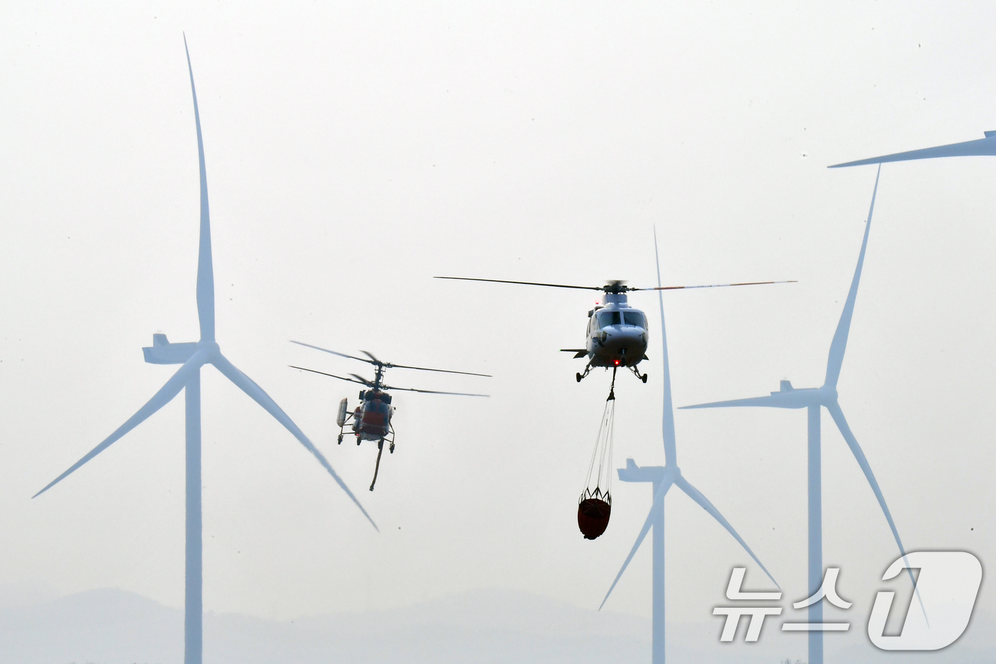 (영덕=뉴스1) 최창호 기자 = 23일 오후 경북 영덕군 창포리 풍력발전단지 내 풍력발전기에서 발생한 불을 끄기 위해 산림청, 소방, 인근 지자체 헬기들이 진화작업을 벌이고 있다. …