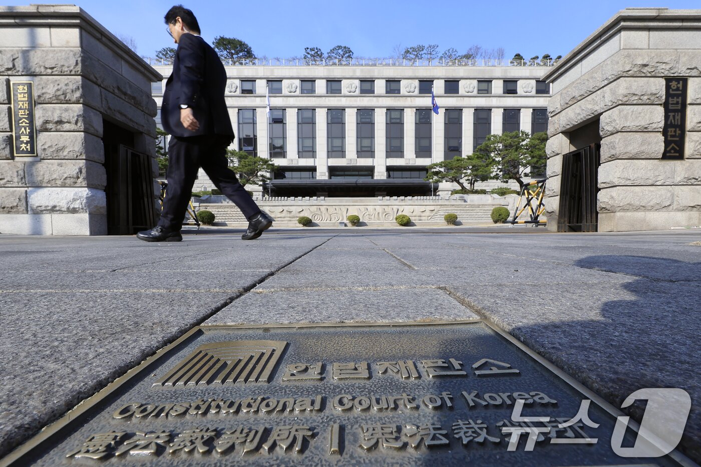 본문 이미지 - 24일 서울시 종로구 재동 헌법재판소 앞으로 관계자가 지나고 있다. 법조계에 따르면 헌재는 이르면 이날 지정재판부 재판관 평의를 마친 일부 재판소원 사건에 관해 각하 또는 심판 회부 여부를 내놓을 것으로 전망된다. 2026.3.24 ⓒ 뉴스1 박정호 기자