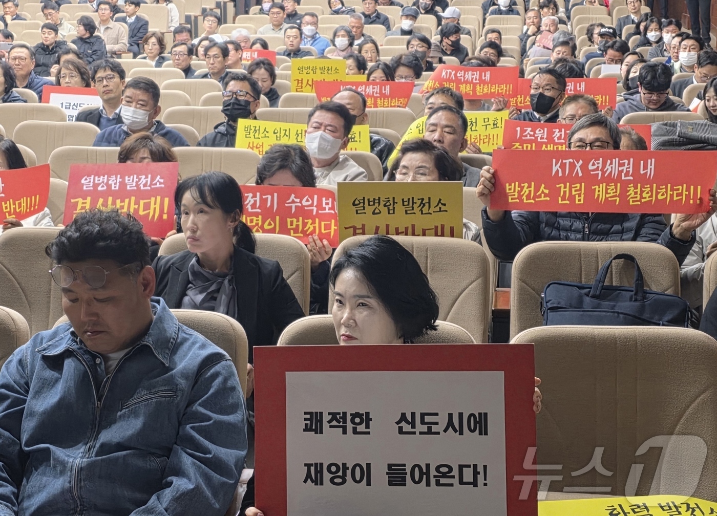 (아산=뉴스1) 이시우 기자 = 24일 충남 아산시 선문대학교 본관 대강당에서 열린 '아산 열병합발전사업 환경‧기후변화 영향평가서(초안) 공청회'에서 시민들이 손팻말을 들고 사업 …