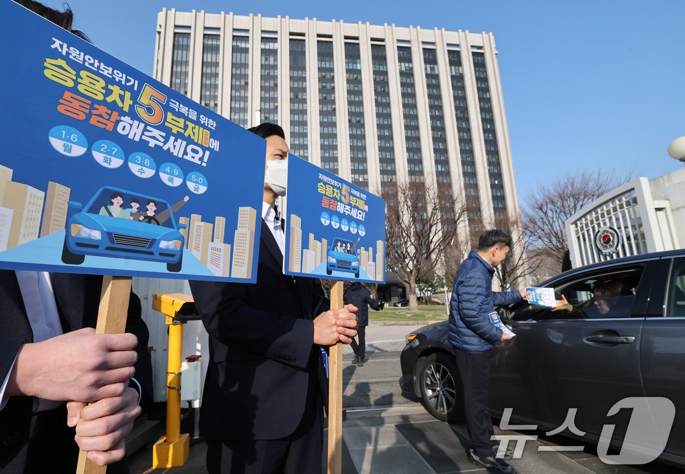 본문 이미지 - 25일 서울 종로구 정부서울청사 앞에서 청사 직원들이 원유 안보위기 ‘주의’ 경보 발령에 따른 공공 차량 5부제 캠페인을 벌이고 있다.  2026.3.25 ⓒ 뉴스1 임세영 기자